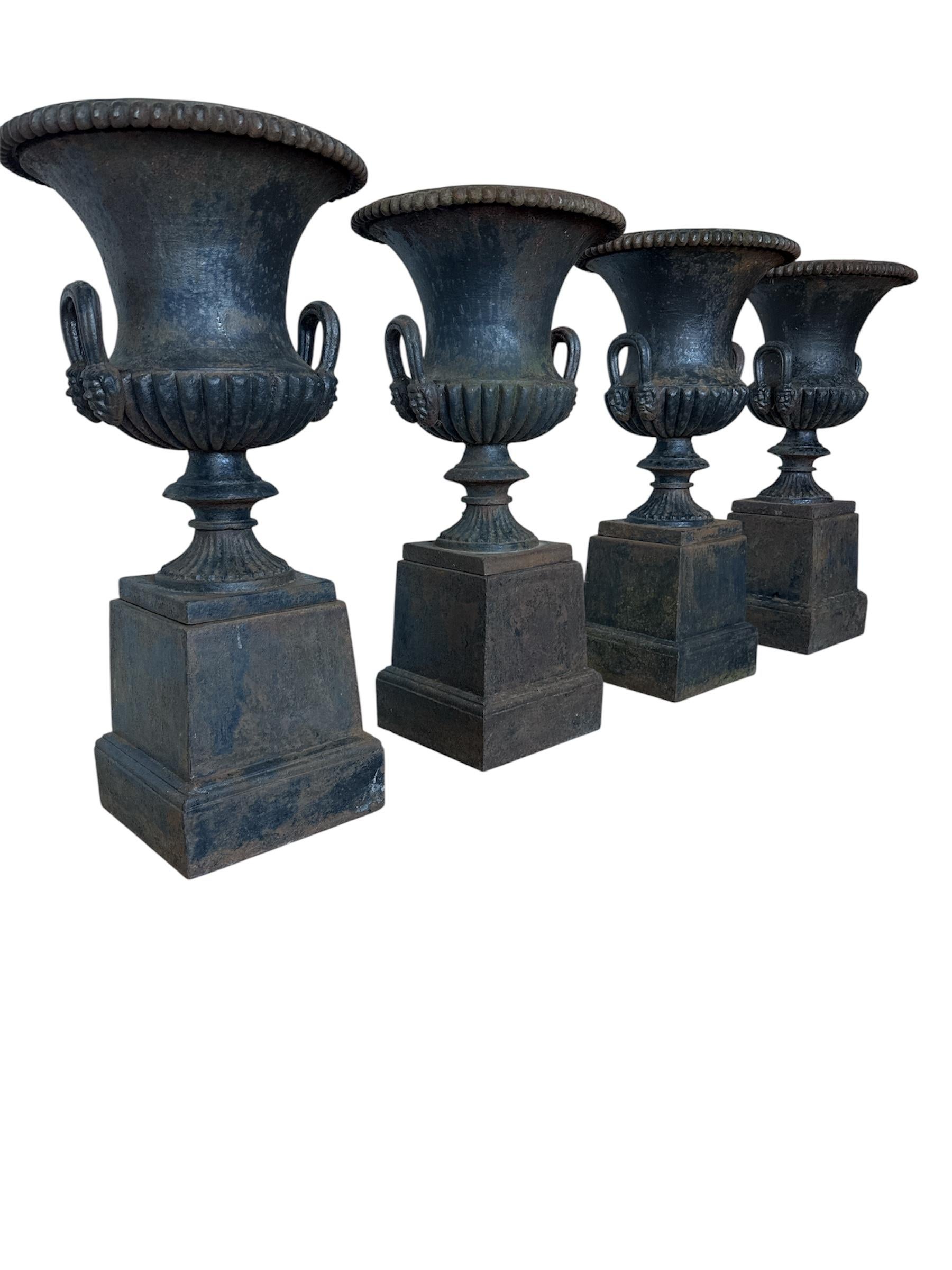 This set is four identical urns with bases are made of black cast iron and has a beautiful outdoor patina
Estuary with egg wand decoration, smooth waist, upturned hangers with mascarons, good crowned bottom

Each urn sits on a four-sided raised