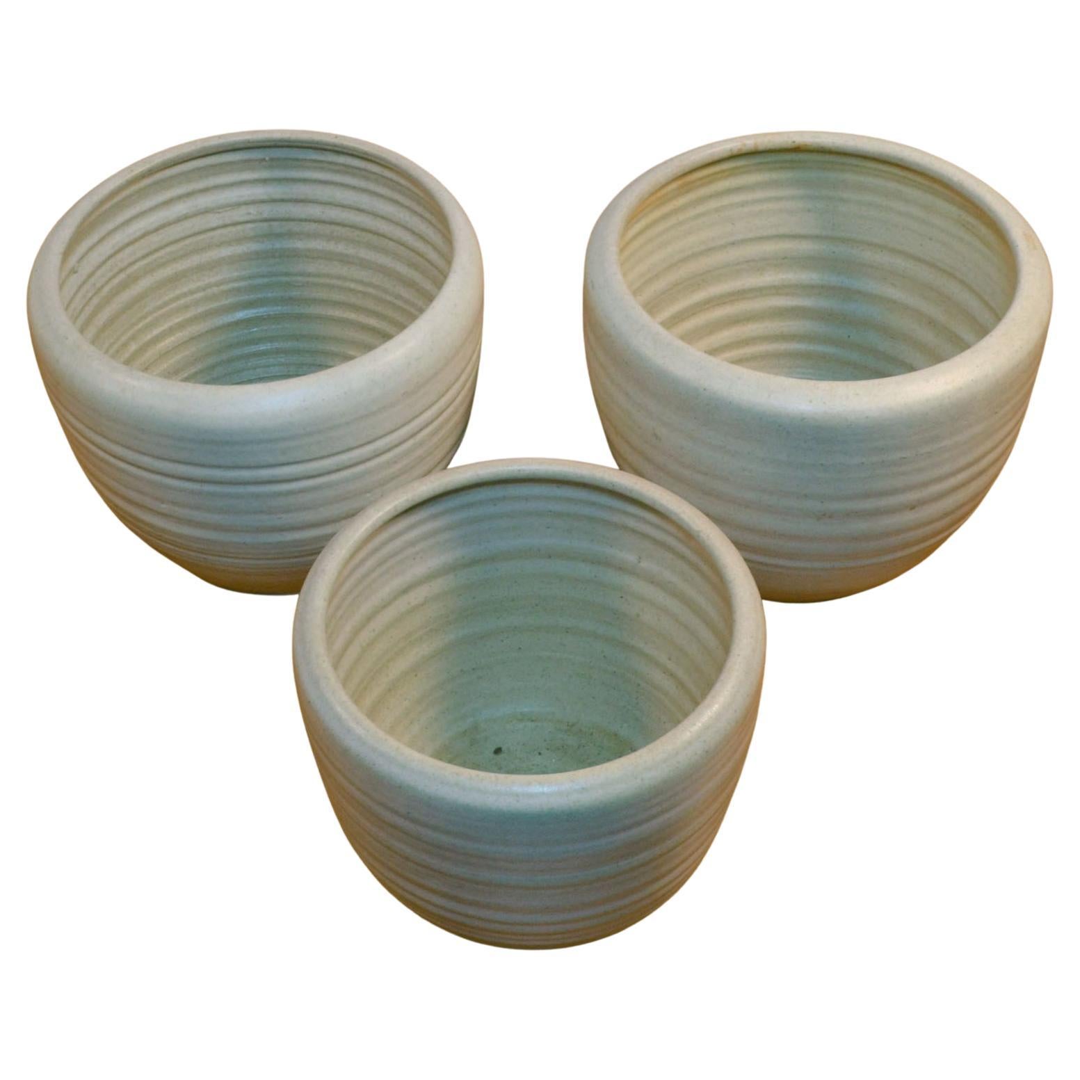 Set of four studio pottery planters in different sizes created on the turning wheel by sophisticated and advanced skilled Dutch ceramist in the 1980's. The warm lustrous oat white and pale yellow glazes of Mobach are inspired by the highly