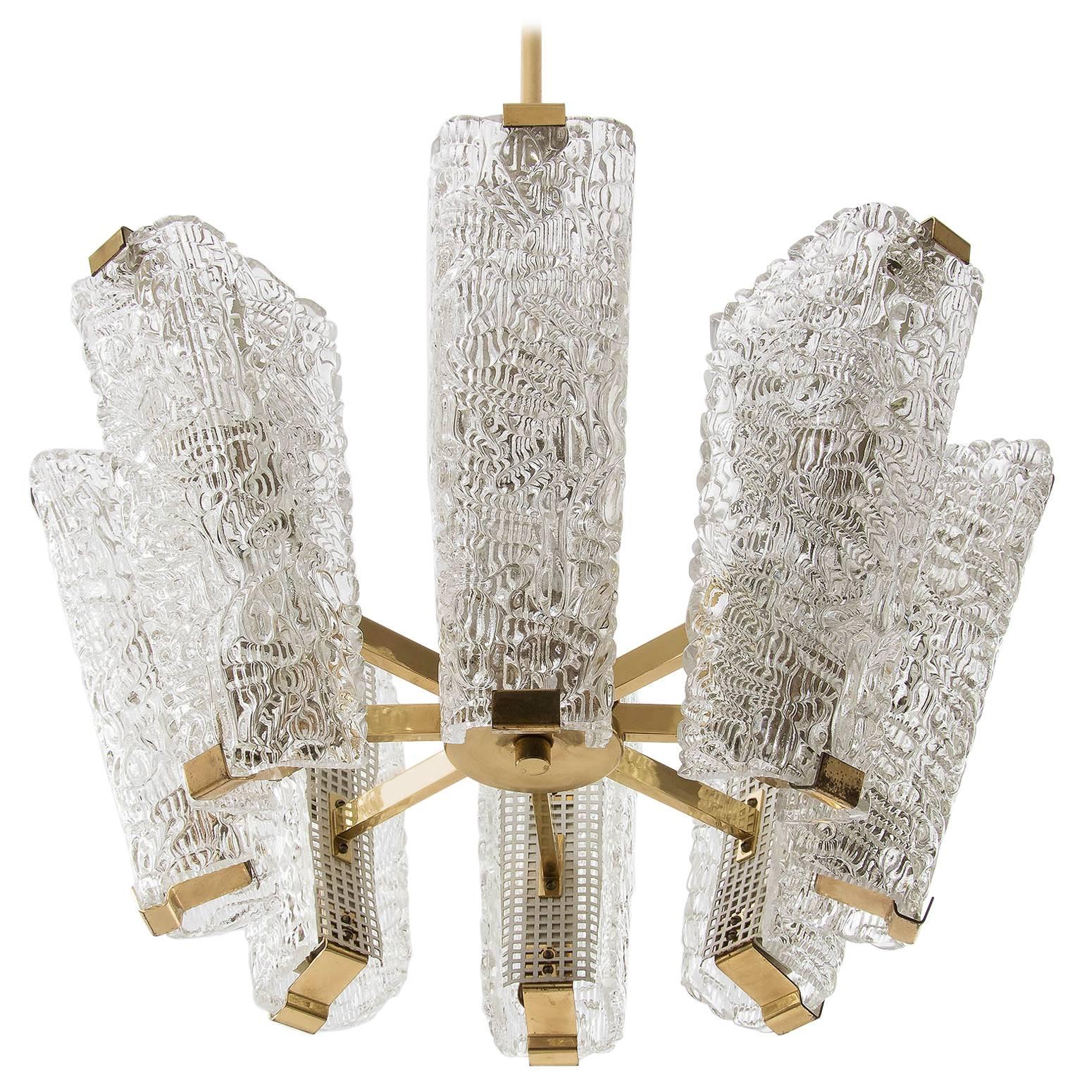 An impressive and large chandeliers by J.T. Kalmar, Austria, manufactured in midcentury, circa 1960 (late 1950s or early 1960s).
The fixture is made of polished brass in a warm tone, textured cast glass and perforated white paint metal.
It has eight