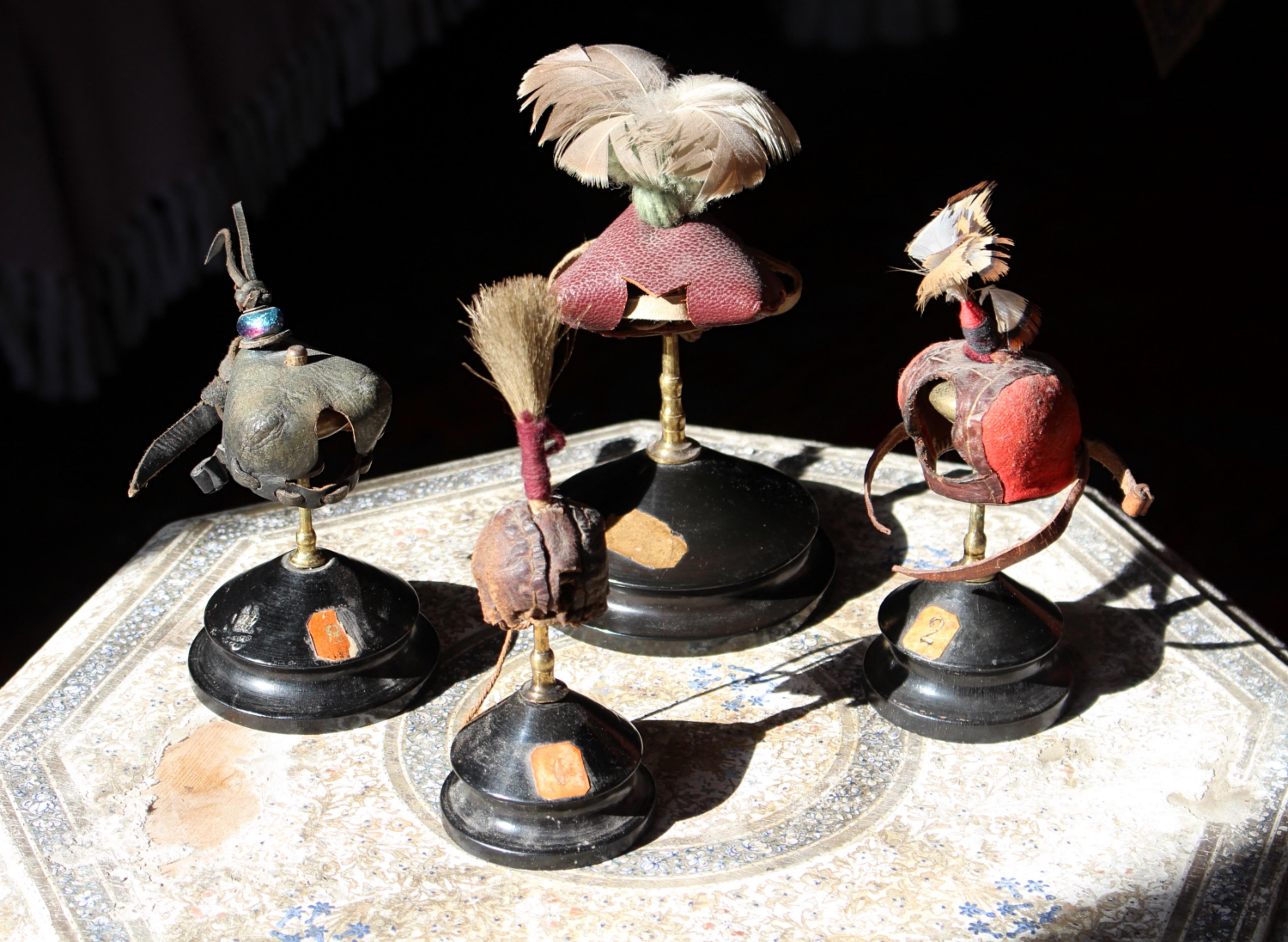 Collection très décorative de quatre hottes de fauconnerie, montées sur des supports assortis en laiton et en bois ébonisé.

Les trois plus grands exemples sont datés du premier au deuxième quart du 20e siècle, en cuir noir et rouge avec des perles