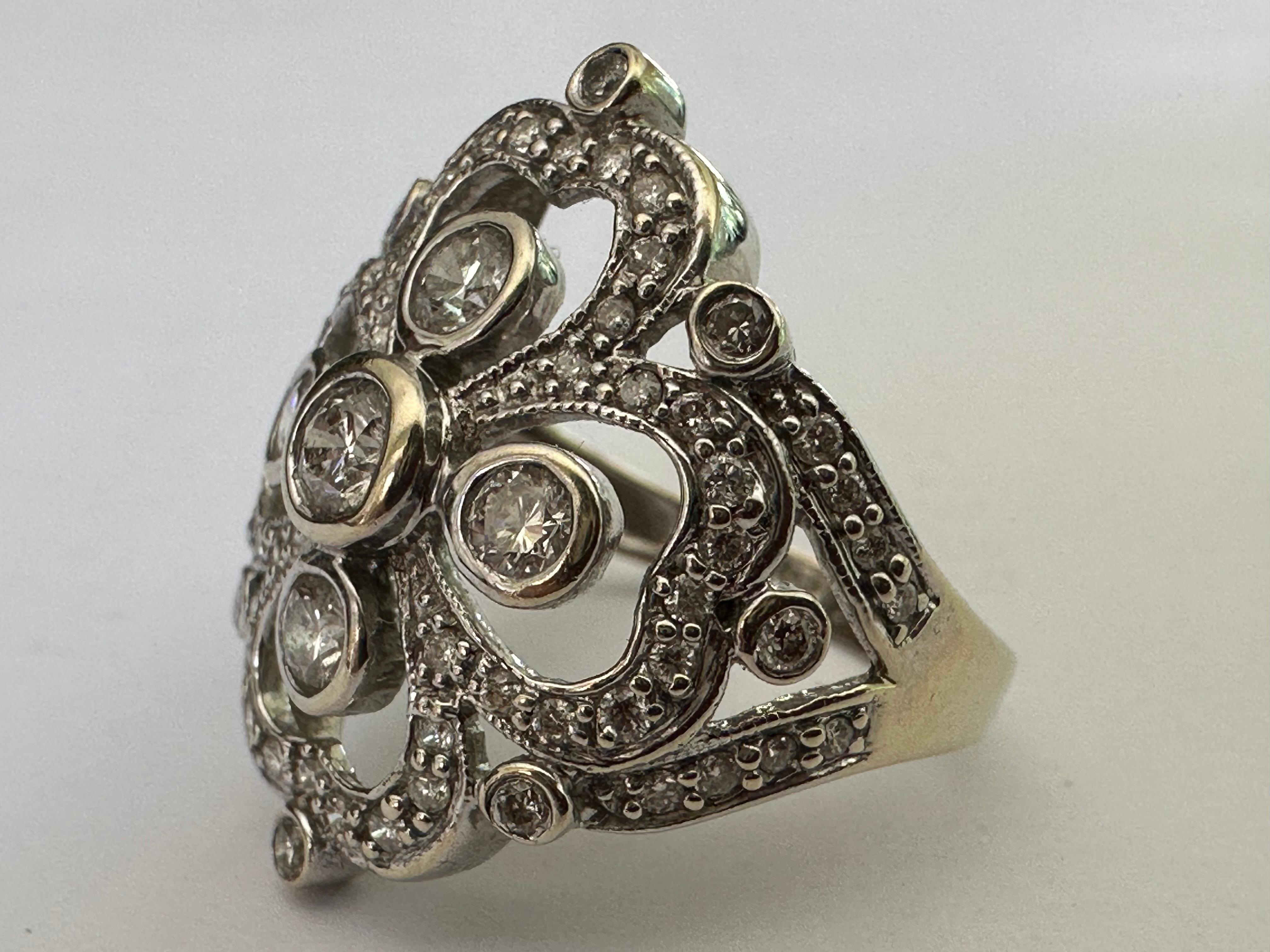 Five round brilliant-cut diamonds together weighing 0.50 carats, F color SI2-I1 clarity, shine at the center of this intricate open work four leaf clover ring crafted from 14K white gold and dotted with tiny diamonds. Total diamond weight,