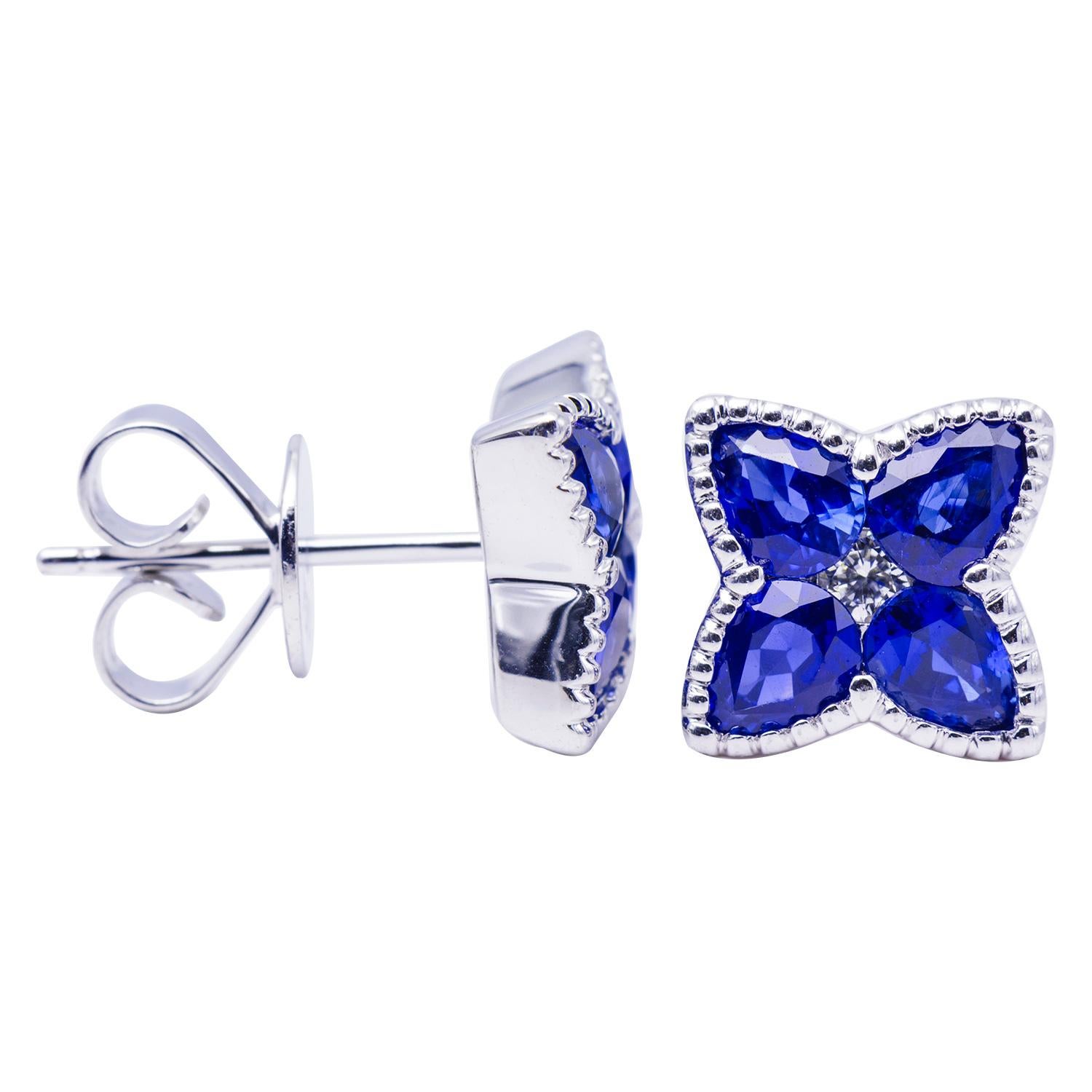 These stunning earrings are made from 8 drop shape sapphires totaling 2 carats with 2 round VS2, G color diamonds in the center totaling 0.08 carats. Around the sapphires is beautiful goldwork made out of 3 grams of 18 karat white gold. These