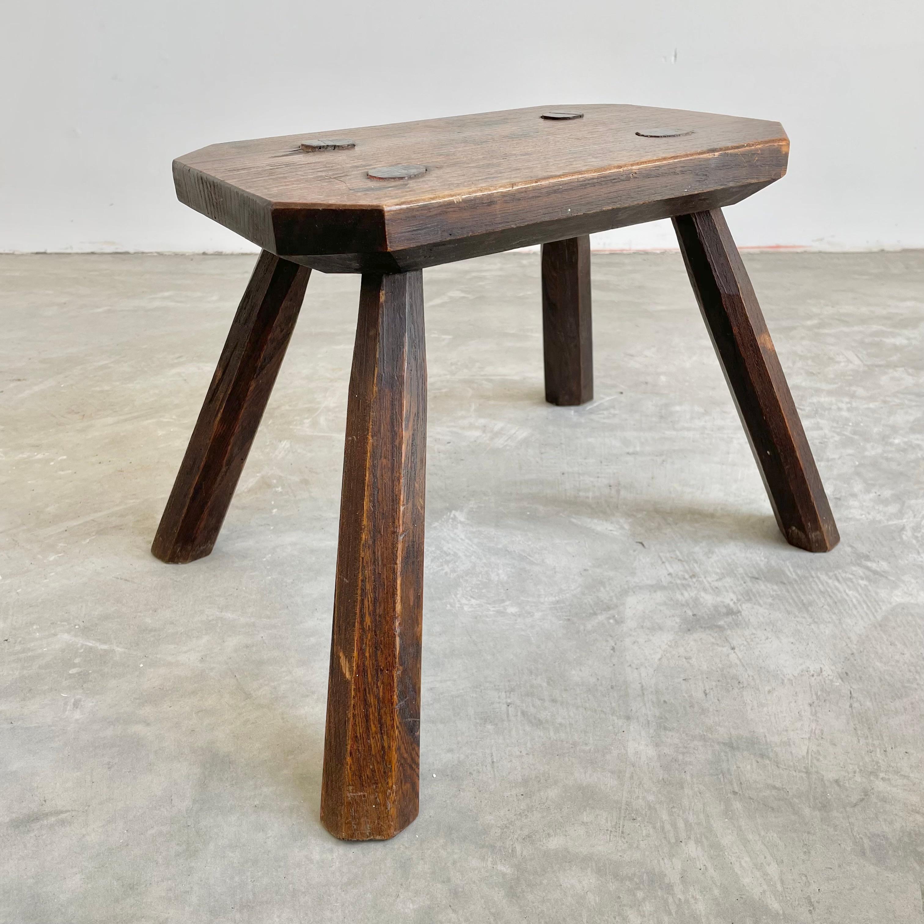 Chunky wooden stool made in France, circa 1960s. Tapered seat and tapered legs. Substantial stool with great lines and posture. Darkened patina and grain to the wood. Perfect for books or objects.
 