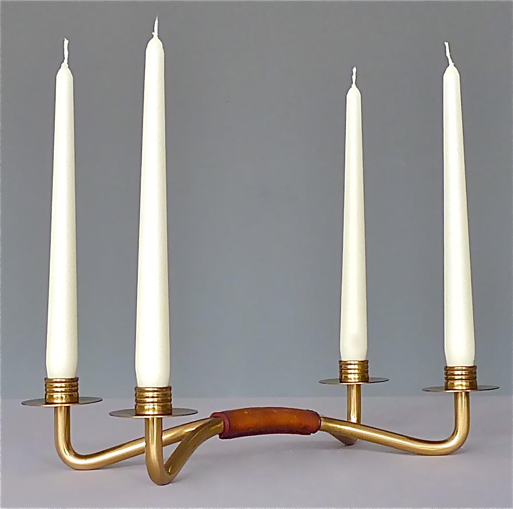 Beautiful Austrian midcentury four-light candleholder in solid patinated brass, hand-stitched patinated leather which probably belongs to one of the wonderful designs by Hagenauer or Kalmar. This 1950s piece is made of best materials and is of high