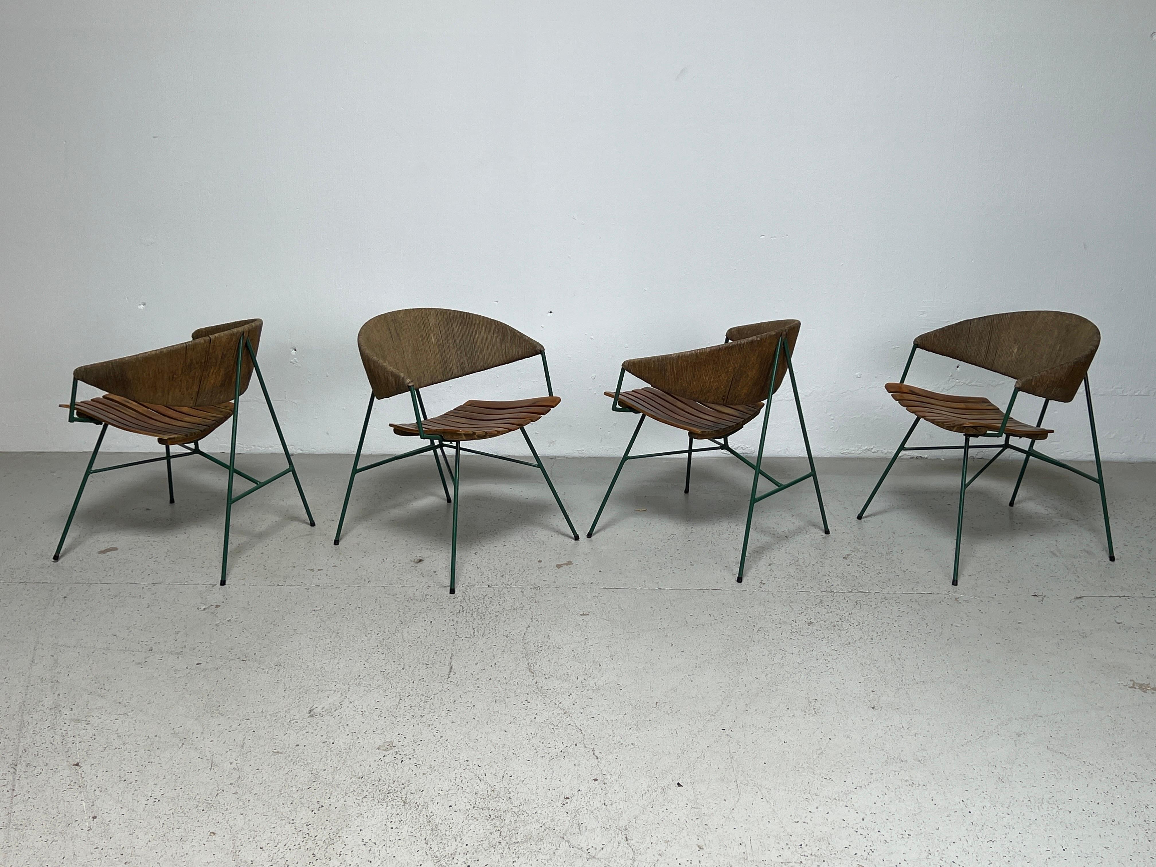 A set of four rare Arthur Umanoff lounge chairs with wooden seats and a rush backs. Nice overall patina. 