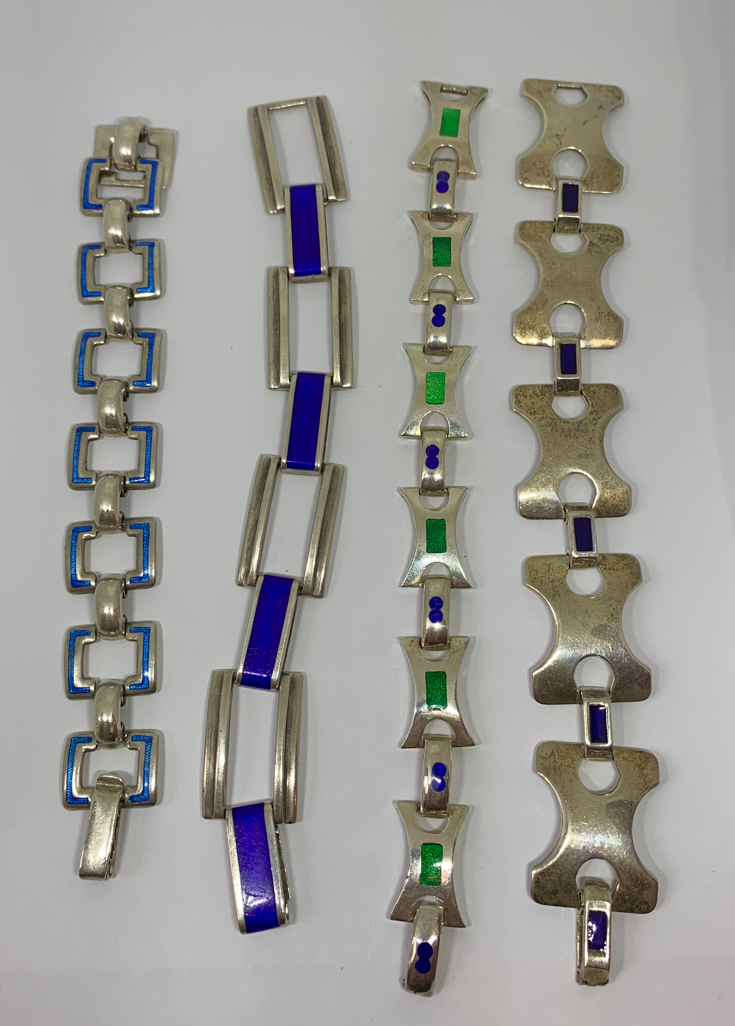 This is an exquisite set of four Mid-Century Modern Bracelets from Italy in Silver with gorgeous blue and green enamel decoration.  The four geometric motif bracelets may be worn together on the arm or singly.  They each have fabulous Mid Century