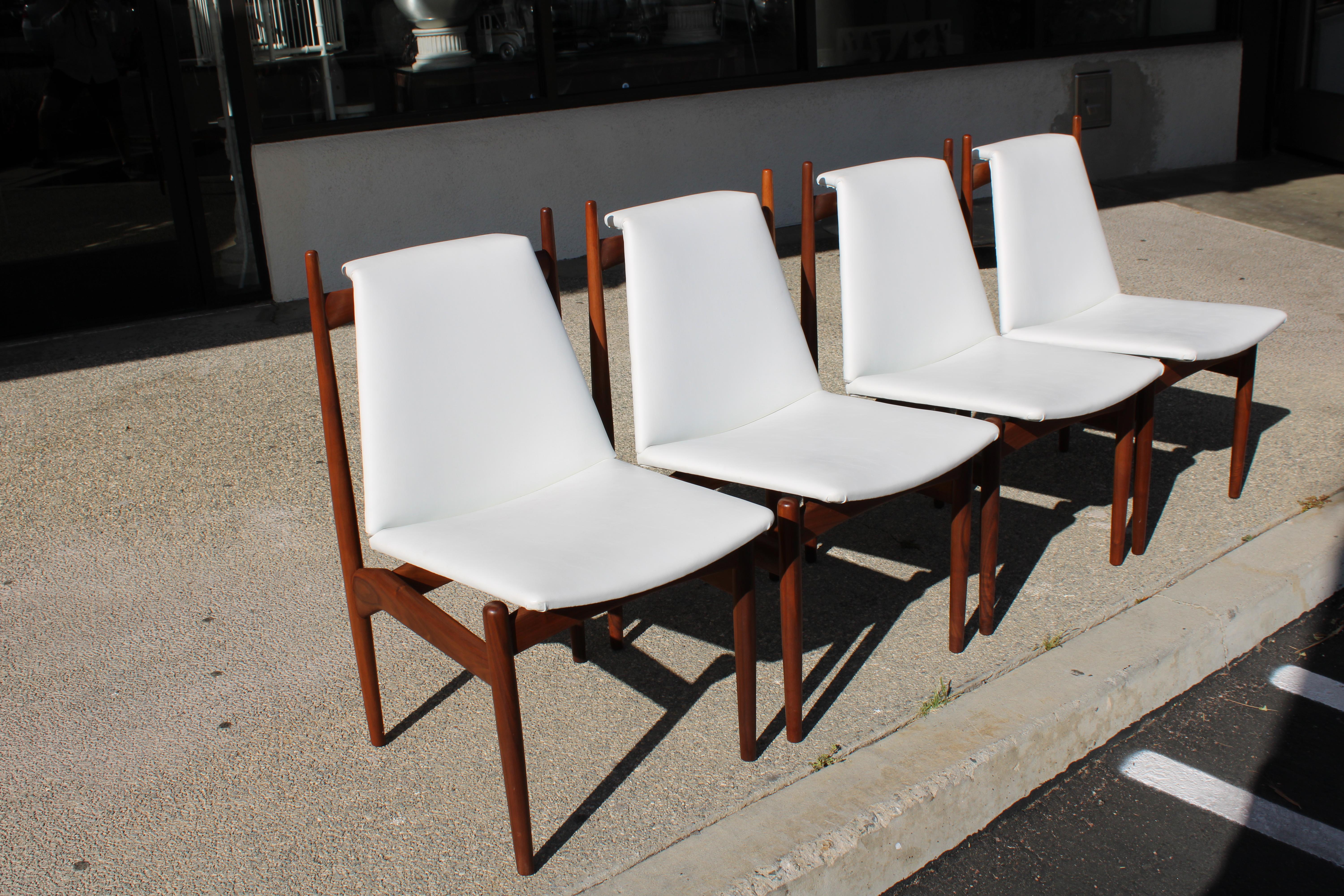Four walnut dining chairs that we believe were designed by Greta Grossman for Glenn of California. The original owner said these chairs had a partial label stating they were from Van Nuys, CA.  Great design and notice the brass at the top of the