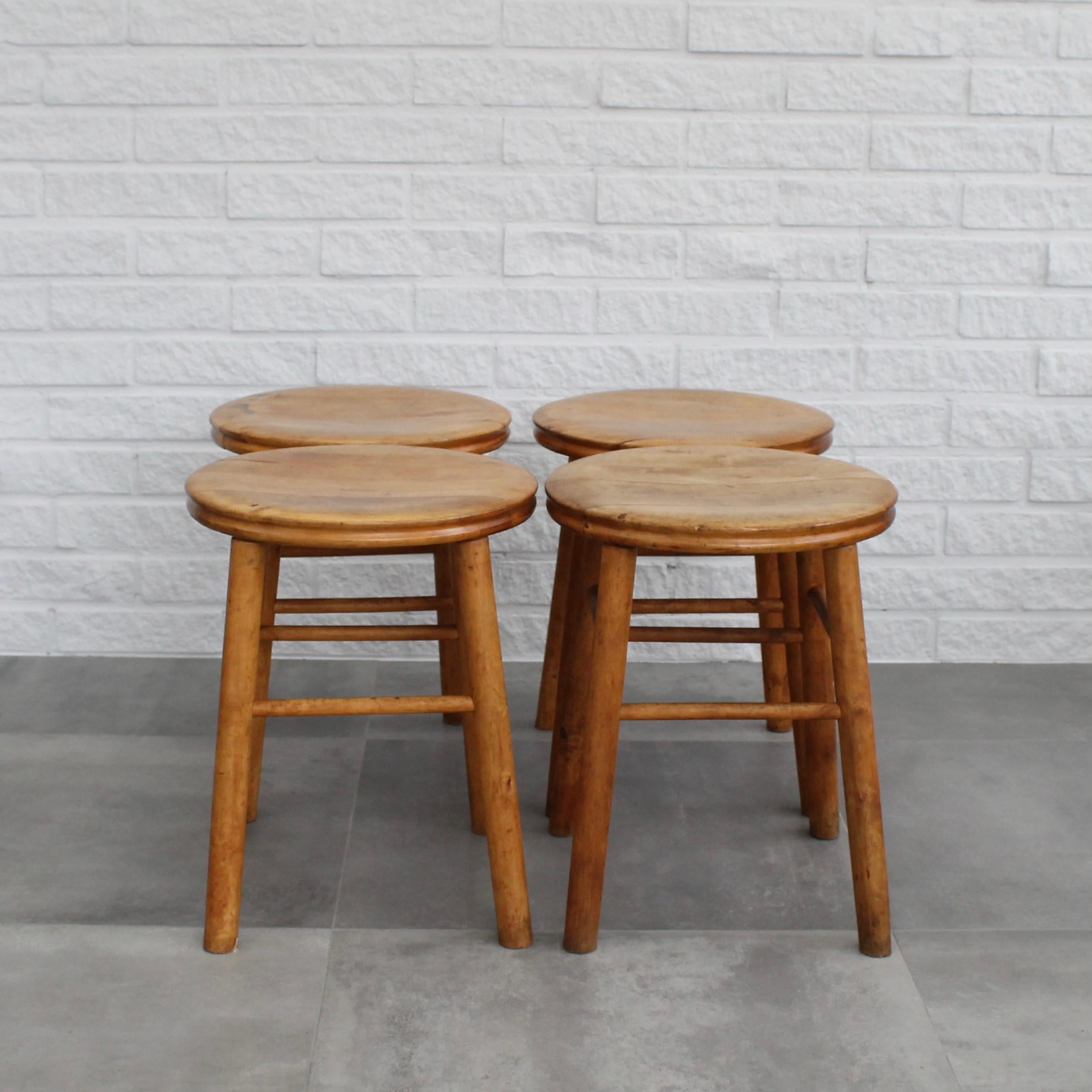 Four Swedish birchwood stools from the 1930s with inspiration from antique peasant furniture. Showcasing a minimalist design characterized by straight legs connected with stretchers and a somewhat bowl-shaped round seat. 