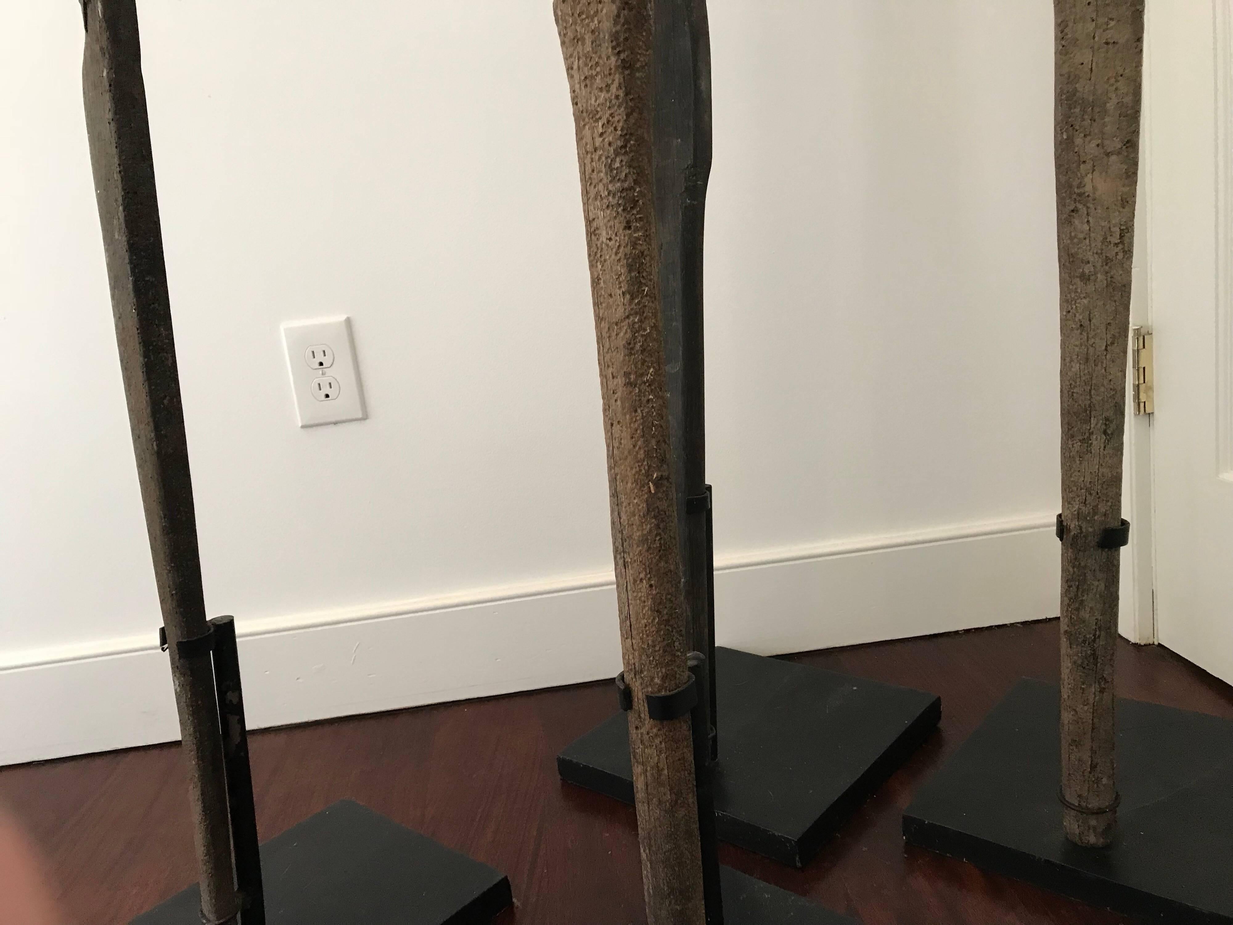 A set of four antique wood oars of various height from Bali. Each mounted on museum quality metal base. Tallest measures 112