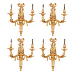 Vier zweiflammige Wandleuchter aus vergoldeter Bronze im neoklassischen Stil
