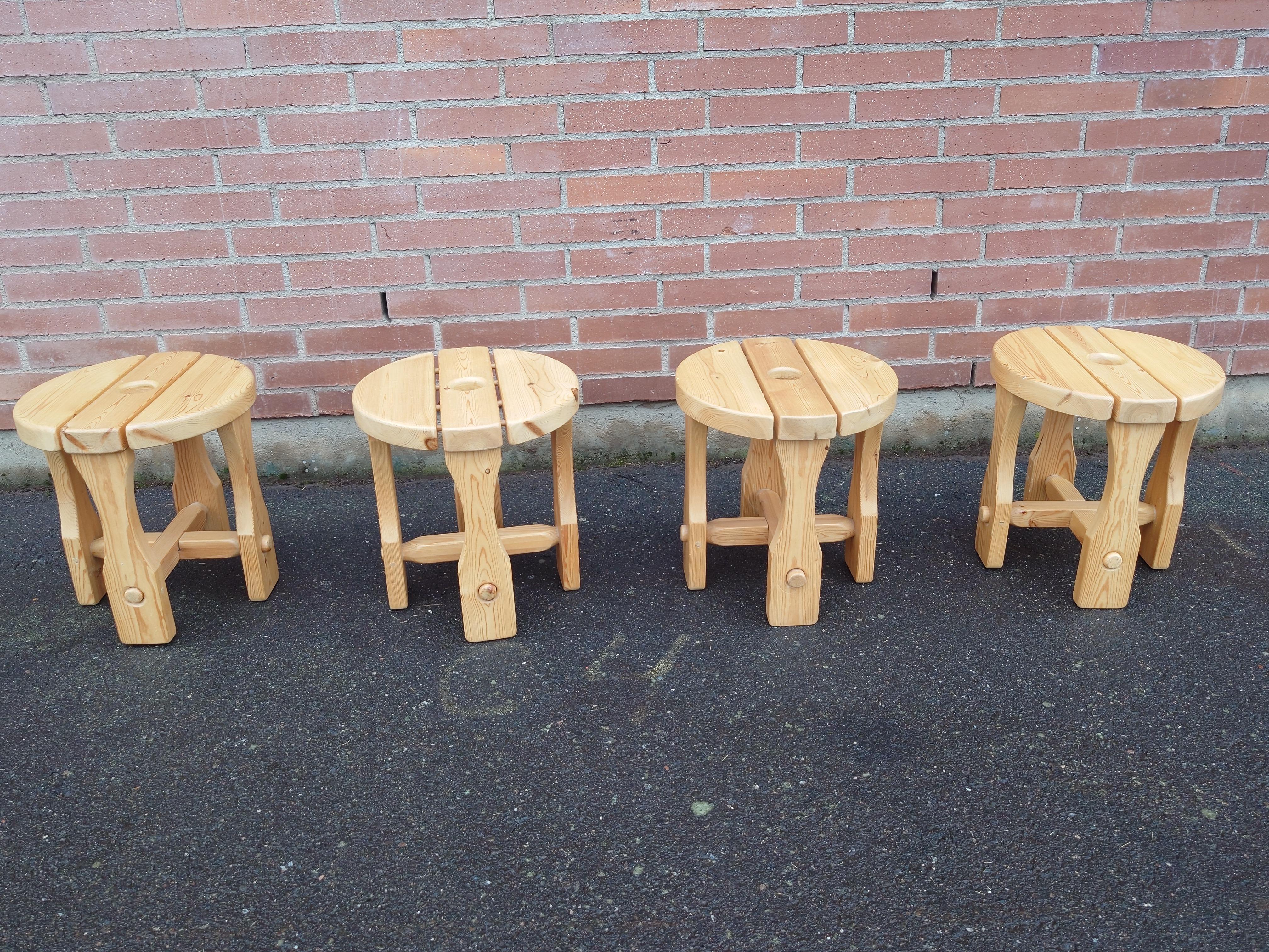  Un ensemble de quatre tabourets rustiques en pin, datant des années 1970. Ces tabourets sont construits en pin massif, présentant un grain de bois naturel et une construction durable. Idéales pour divers contextes, elles peuvent servir de sièges