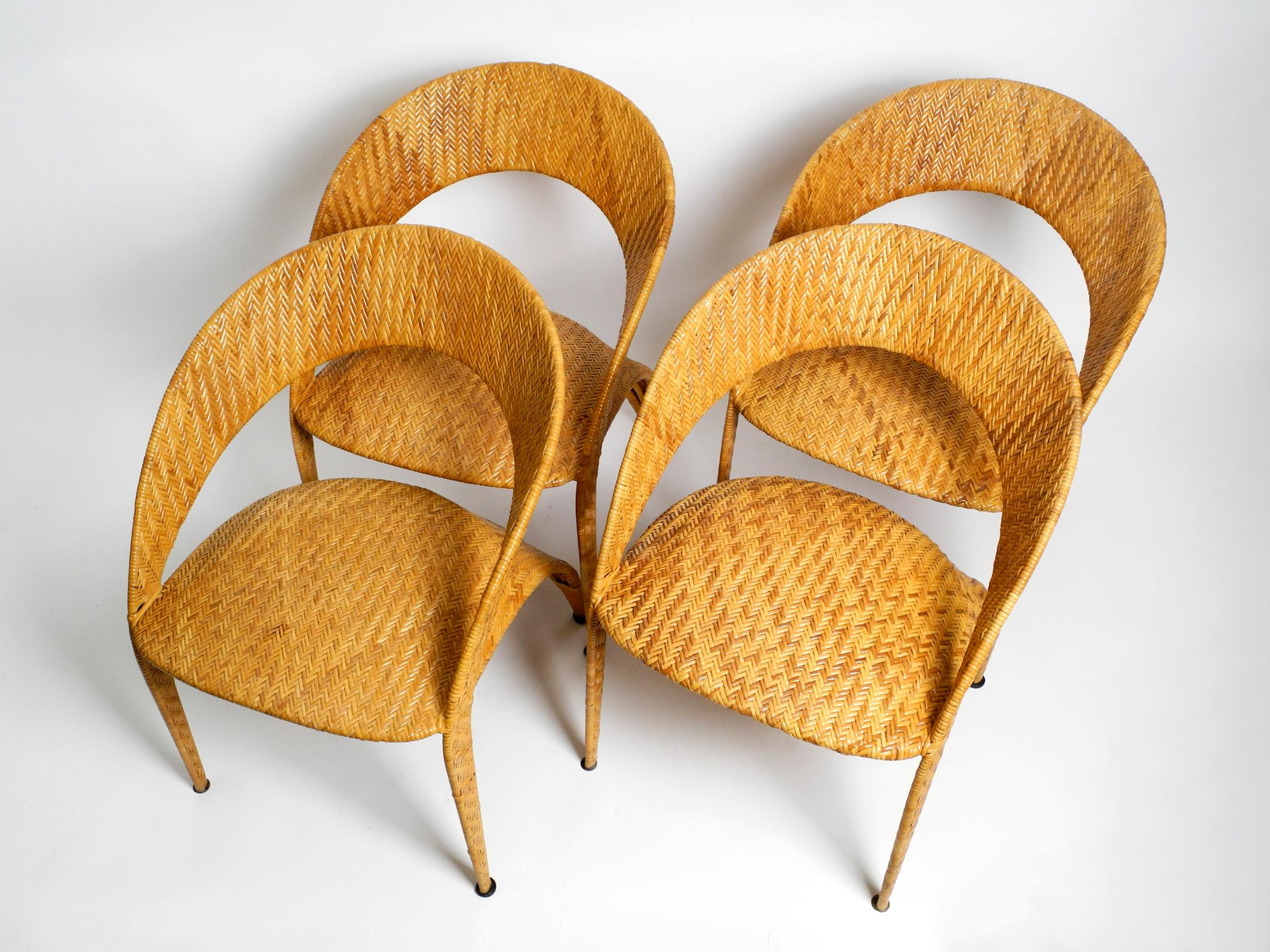 Four original 1980s rattan armchairs.
Great, very unusual Postmodern design.
With upholstered seat. As a dining room set or for  the living room or lounge.
All four chairs are in very good condition with no damage and in the same condition.
No