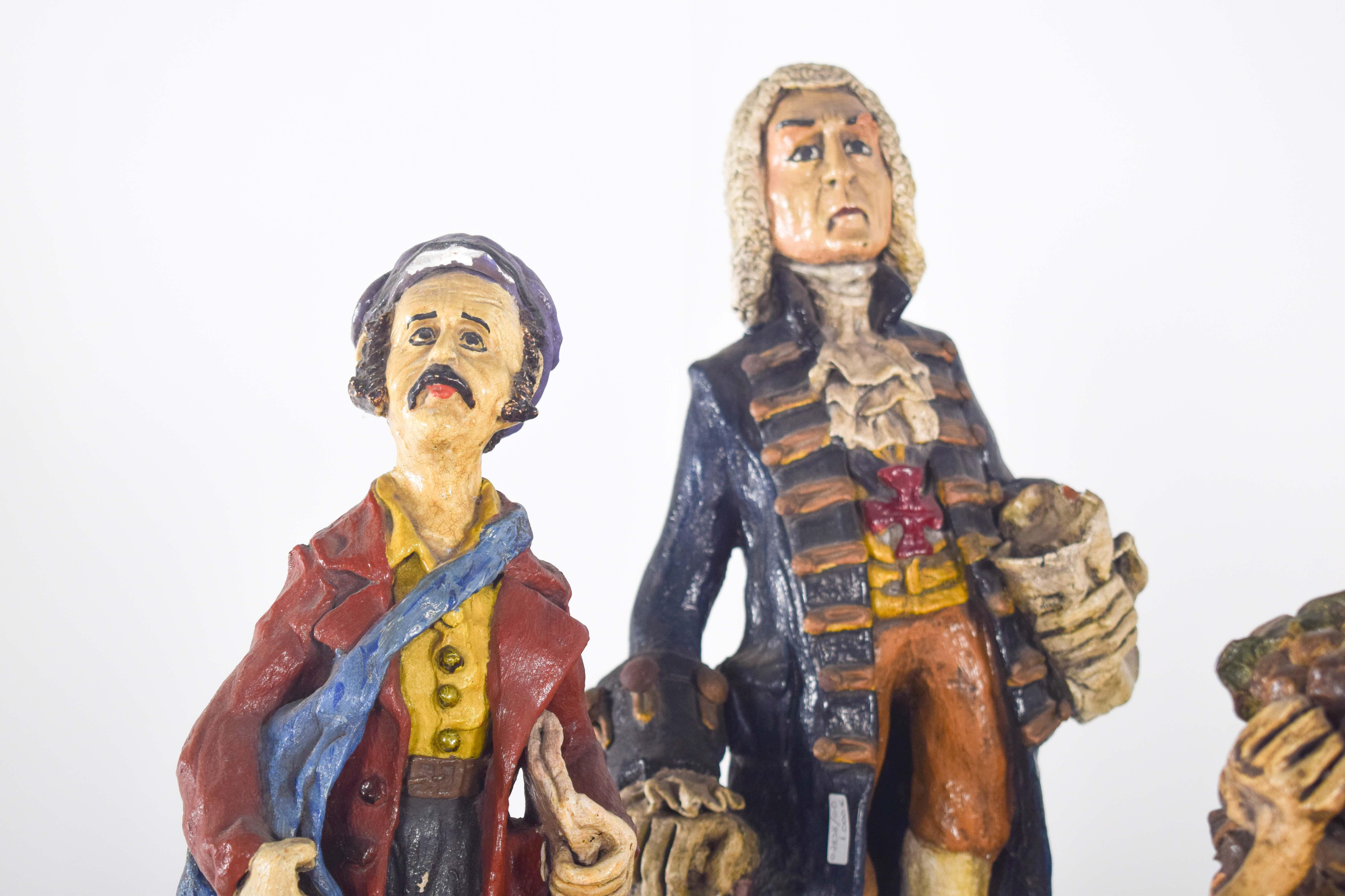 Cuatro esculturas de arcilla pintada del ceramista Solrac, hechas y decoradas a mano. Representan a personajes de la sociedad portuguesa, un vendedor de periódicos, un vendimiador, un cazador y el marqués de Pombal. Decoración policromada con