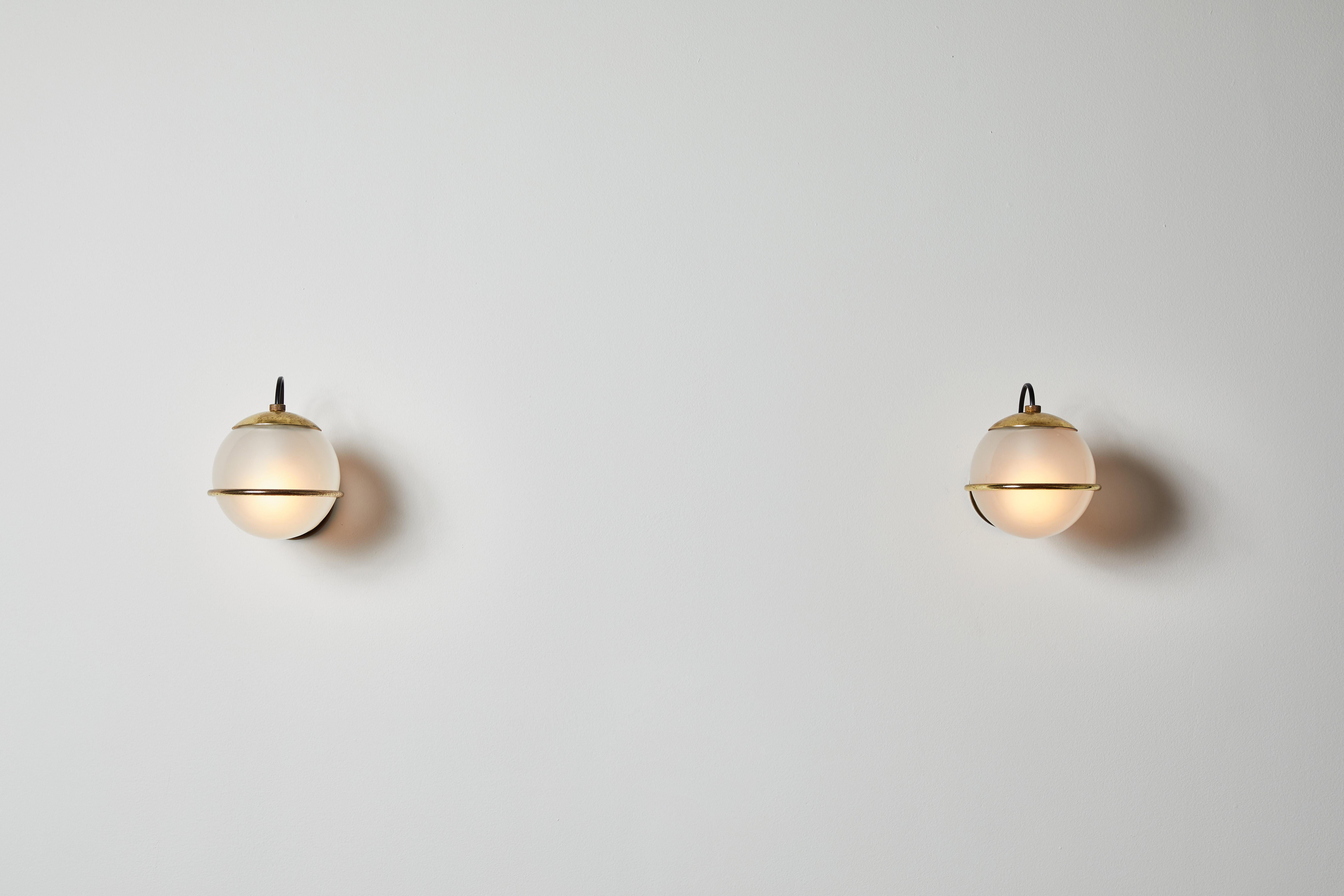  Pair of Model 237/1 sconces by Gino Sarfatti for Arteluce. Designed and manufactured in Italy, 1959. Brass armature, opaline glass diffuser. Rewired for U.S. junction boxes. Each light takes one 60w European candelabra bulb. Bulbs provided as a