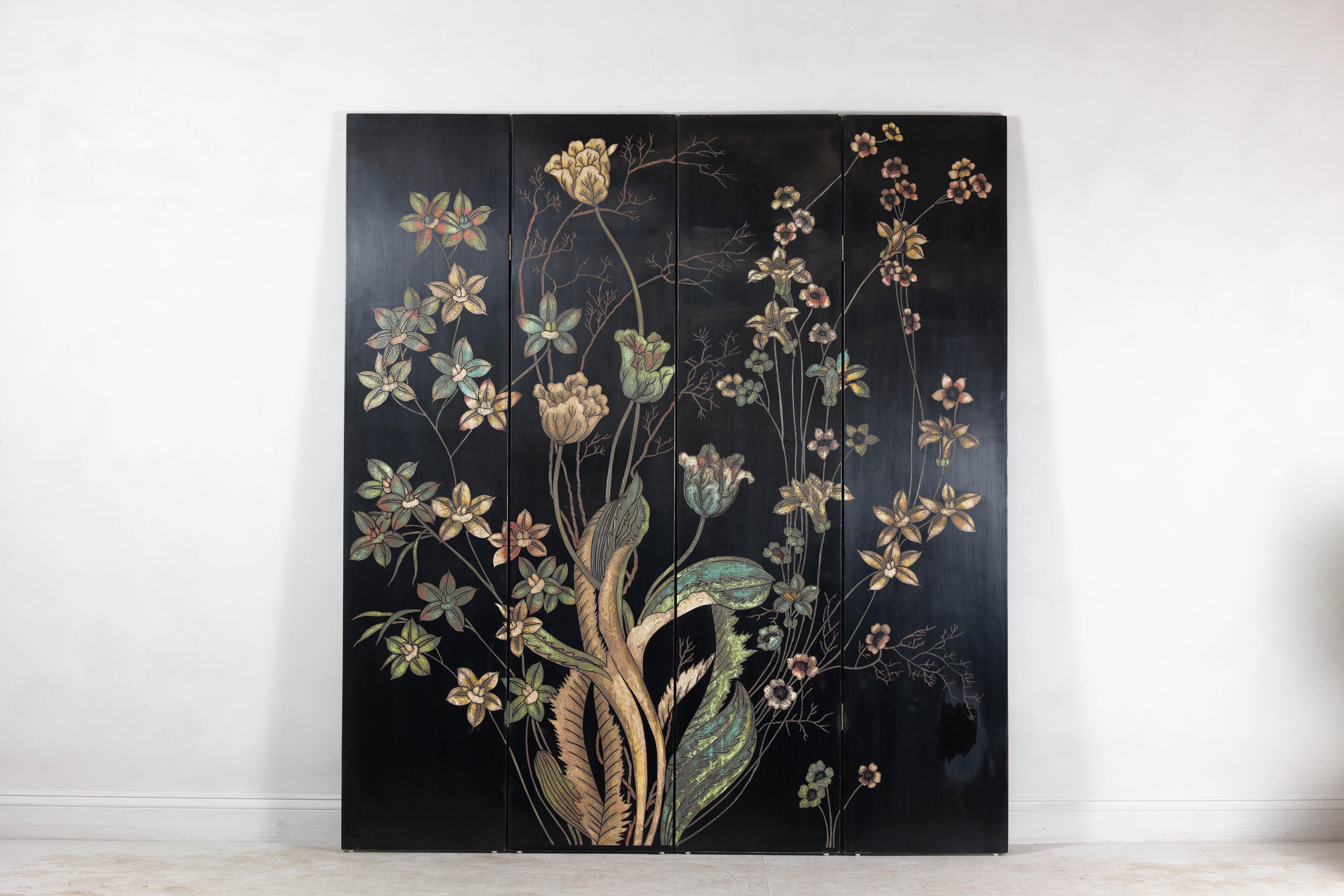 Una vivace composizione floreale anima questo paravento pieghevole a quattro pannelli, realizzato in lacca nera su legno. Il design evoca uno studio botanico pittorico, con delicati steli di fiori che si arrampicano sulla superficie in una