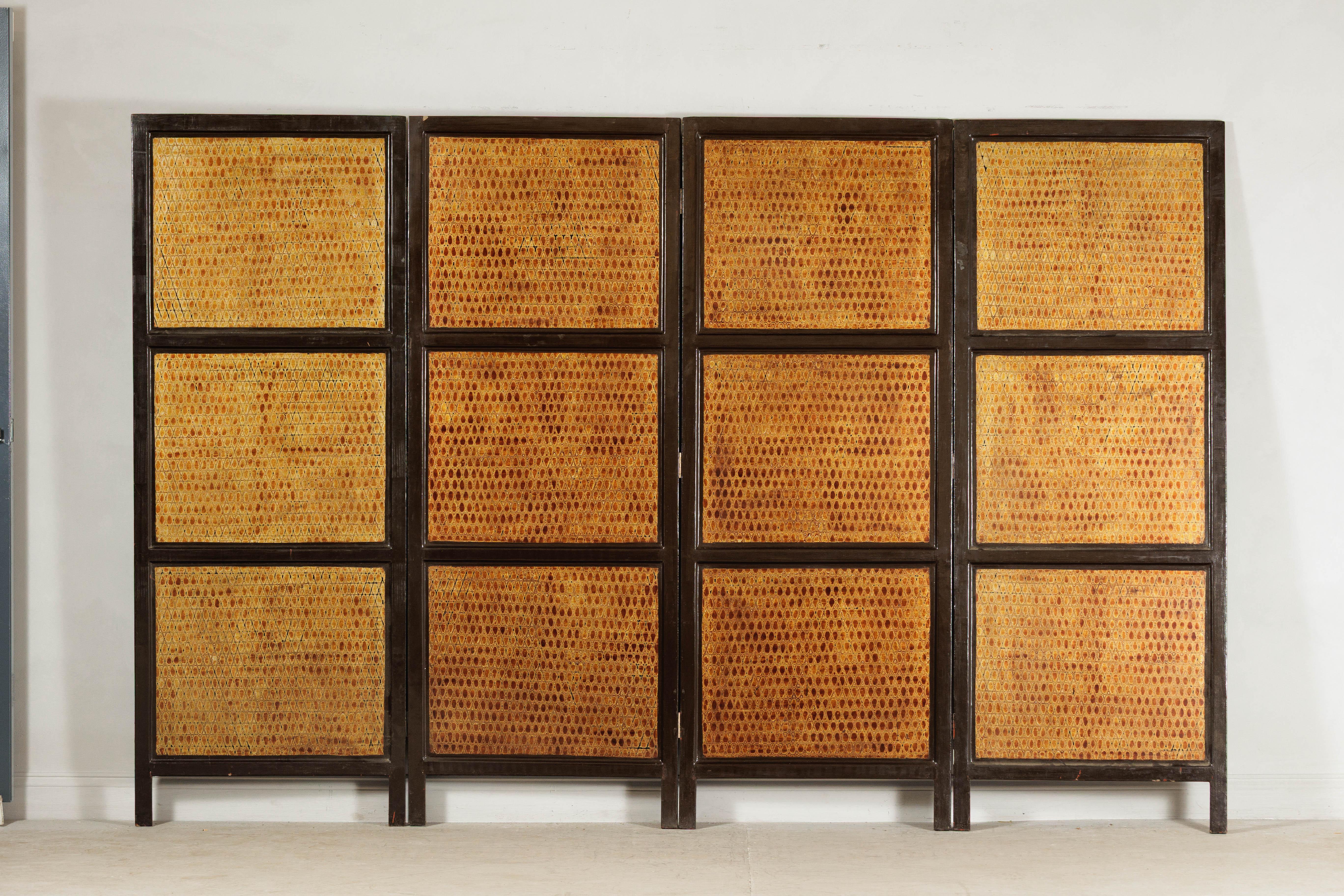 Este biombo vintage de cuatro paneles presenta una llamativa superficie texturada con un acabado de laca Negora ricamente estratificada, una técnica decorativa conocida por su craquelado orgánico, casi reptiliano. Cada panel se compone de secciones