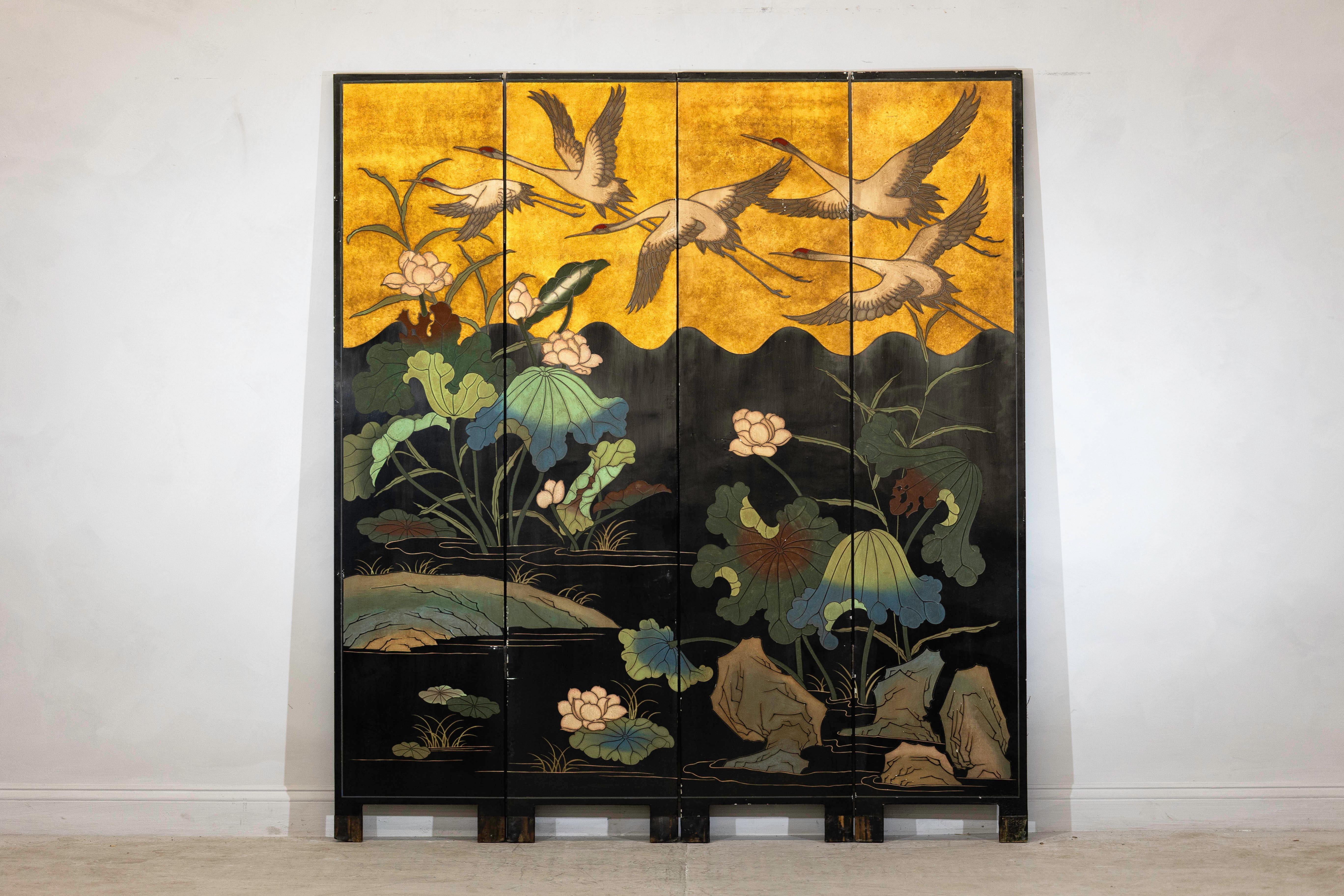 Remarquable paravent chinois à quatre panneaux, doté d'un opulent fond doré et d'images richement peintes, datant vraisemblablement de la fin du XXe siècle. L'avant de l'écran présente une élégante composition de grues à couronne rouge en vol