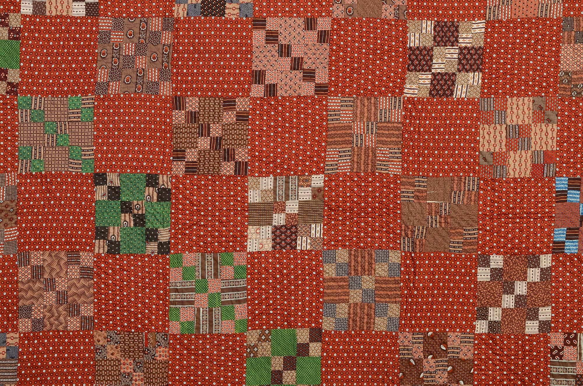 Finely made four-patch in nine-patch quilt from Franklin County, Pennsylvania. Pinned to it is a tag from the Franklin County Quilt Documentation Project. The quilt is made of a lovely assortment of printed 1870s fabrics. The backing is a Bars