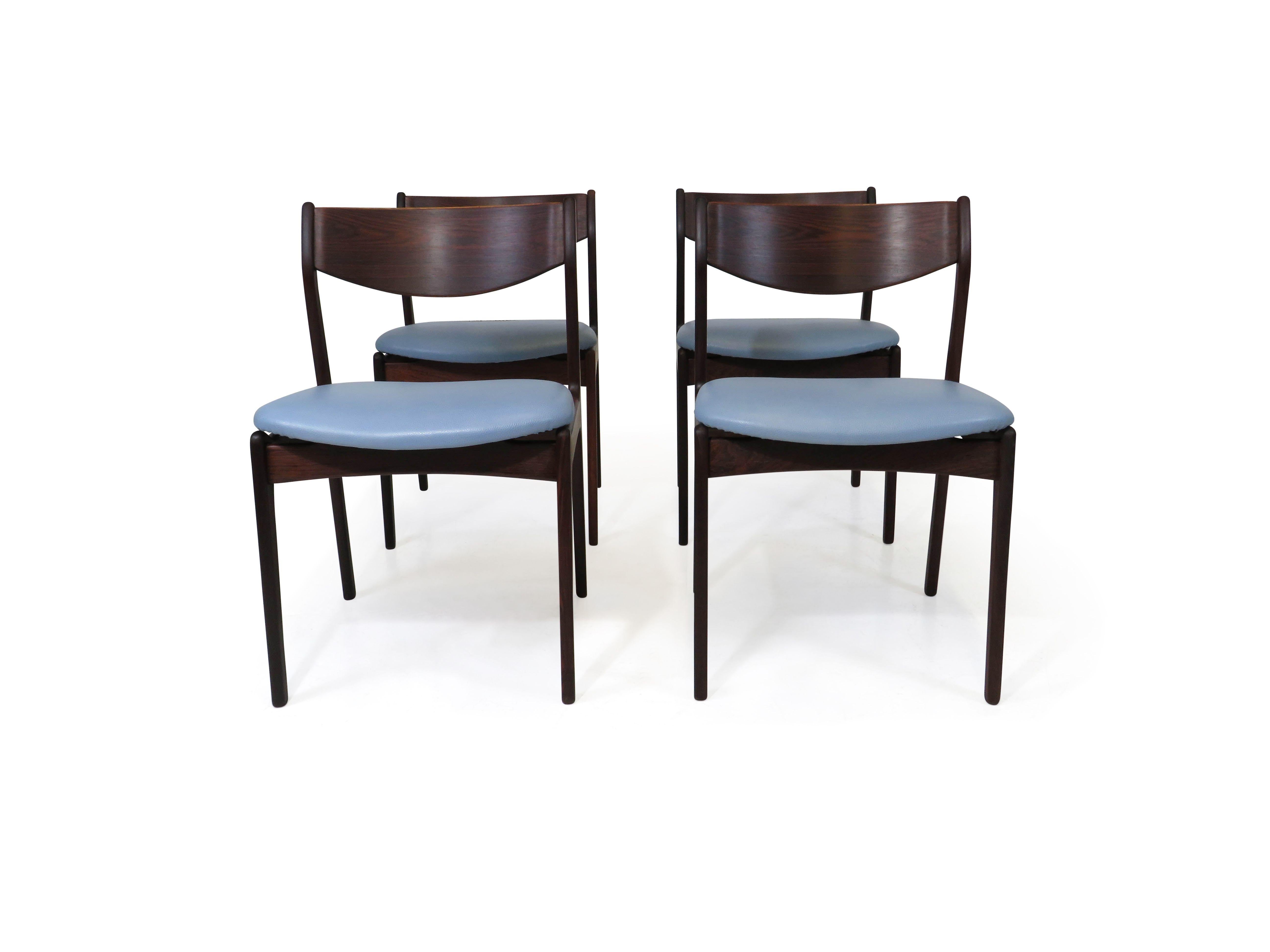 Set of four dining chairs designed by P.E. Jorgensen for Farso Stolefarik crafted of Brazilian rosewood with dark figured grain, and a comfortable backrest, newly upholstered in a durable sky blue leather.  Seat Height 18.50''
 
Note: 18 More chairs