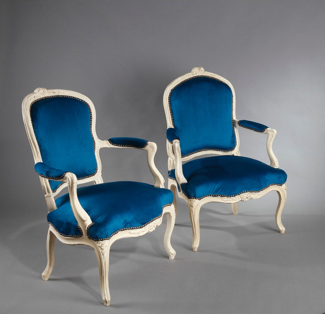 This is a set of four Louis XV period armchairs in walnut wood. They are molded and carved with flowers. Each chair rests on four arched legs and has two sinuous armrests. Three of the seats have a cabriolet shaped back and one has a flat back. The