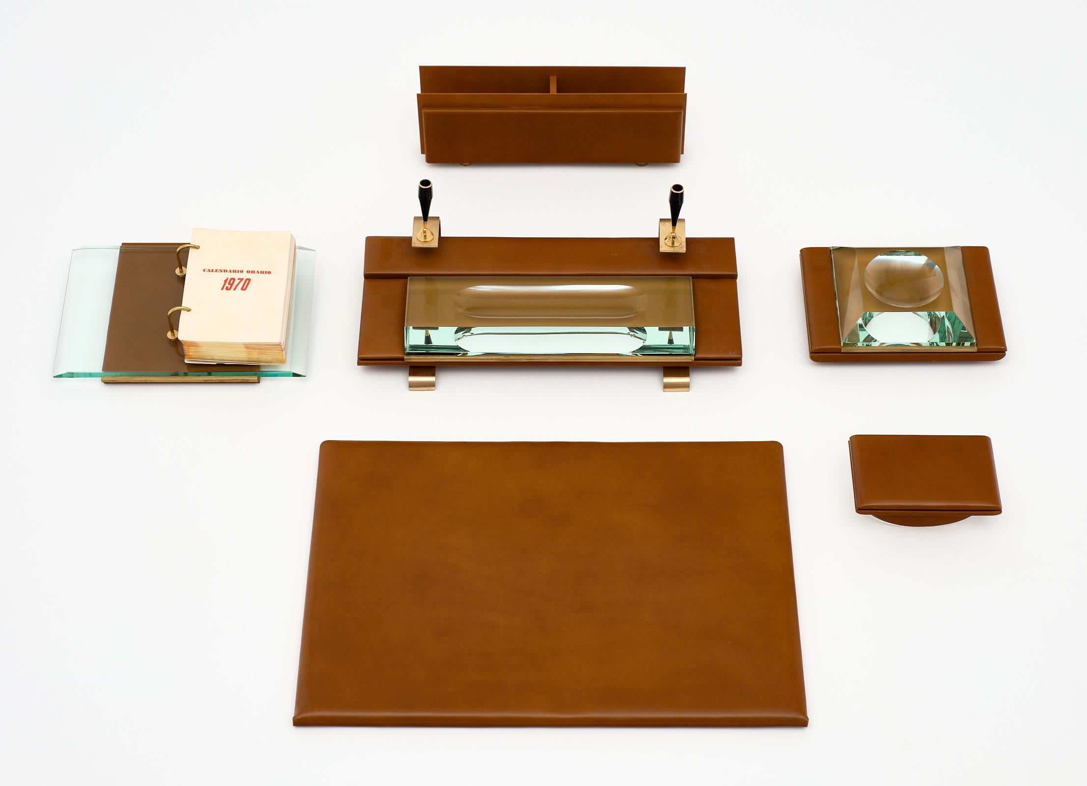 Four-piece 1970s Italian leather desk set - includes leather writing surface; letter holder; 1970s desk calendar; an ink blotter. The dimensions listed are for the writing surface. The letter holder is 12.75” by 3” by 4.5”. The ink blotter is 3.75”