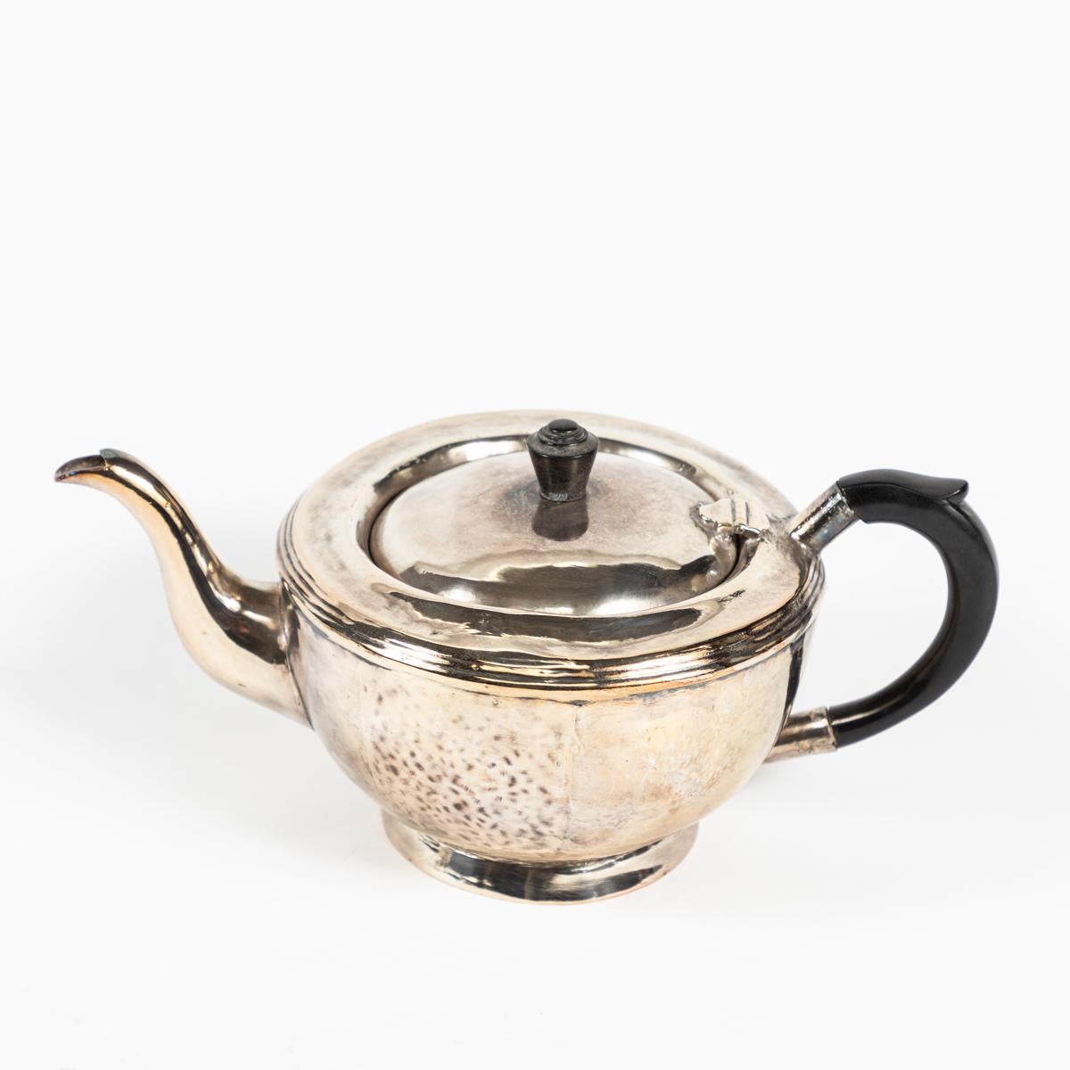 Four piece early 20th-century American hotel silver service for coffee and tea. The teapot and coffee pot feature proto-Modernist carved ebonized handles. The sugar pot and creamer feature simple lines and classic beveling. Elegant and thoughtful in