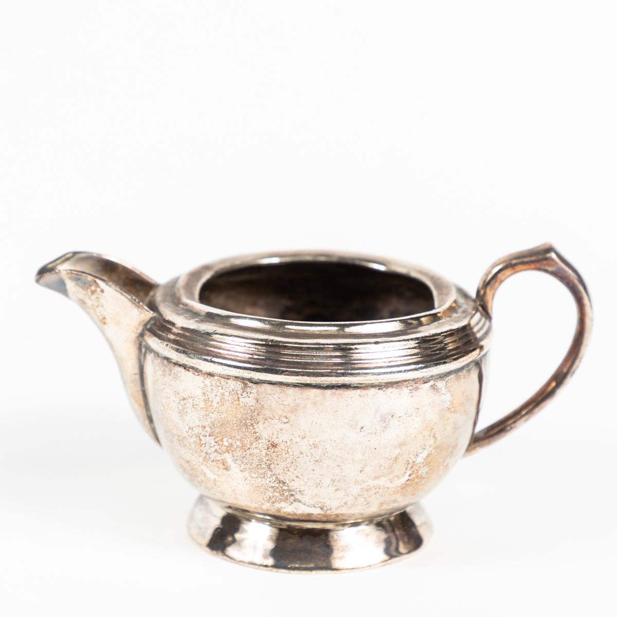 silver teapot with black handle
