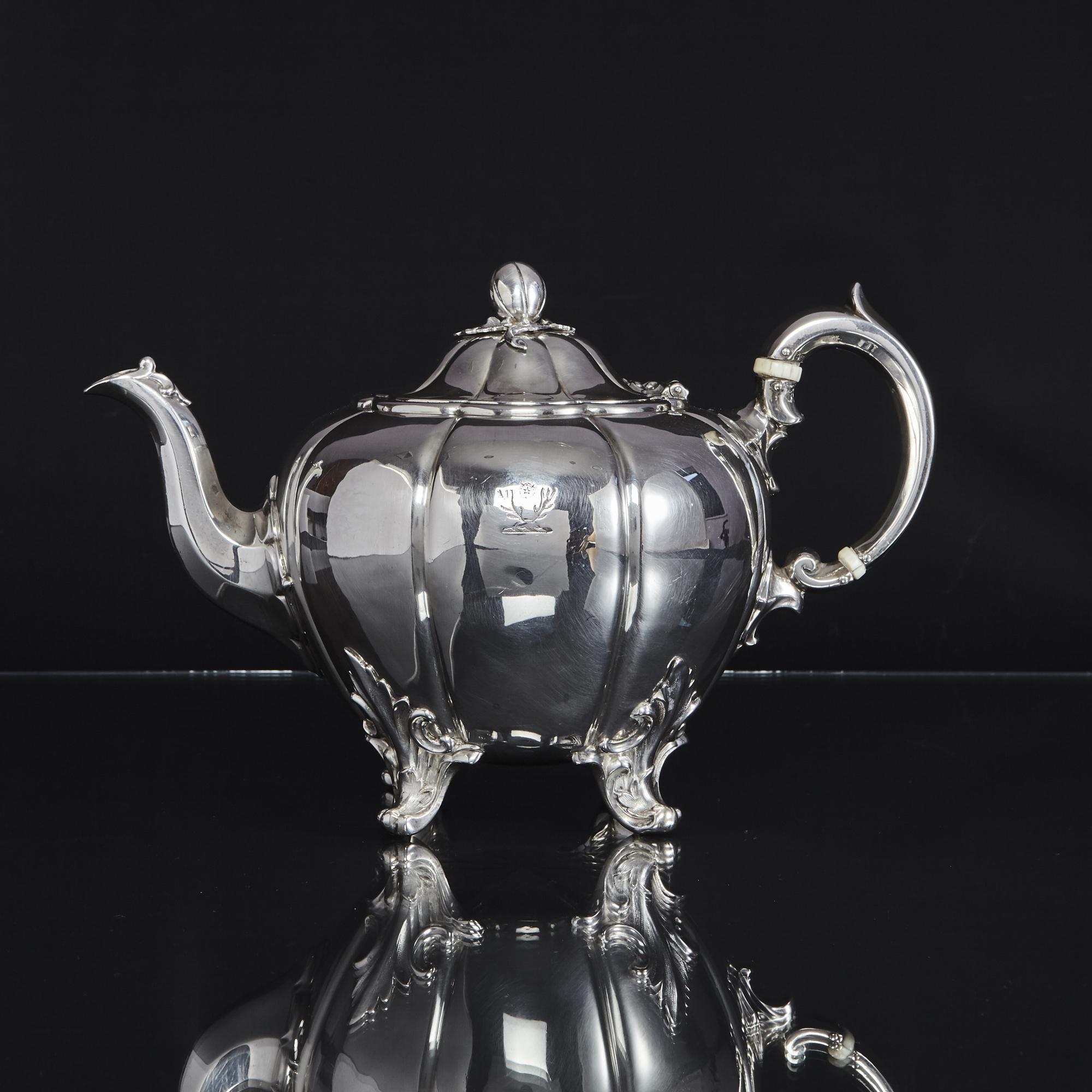An elegant version of the classic melon pattern, this hand-raised, four-piece antique silver tea and coffee set comprises a coffee and tea pot, milk jug and sugar bowl; the latter two pieces have gilded interiors. Each piece rests on four scroll