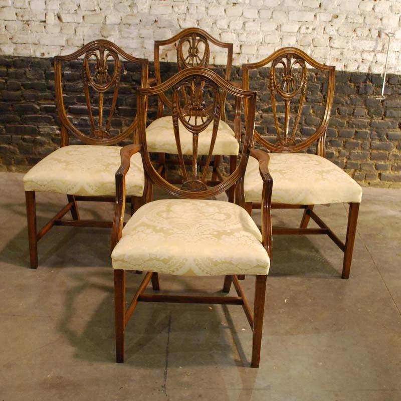 Beautiful set of George III hand carved mahogany dining chairs in the manner of George Hepplewhite.
The chairs all have a shield-shaped lyre back with wheat ear decoration, square tapering legs, and cross stretchers. The solid hand carved mahogany