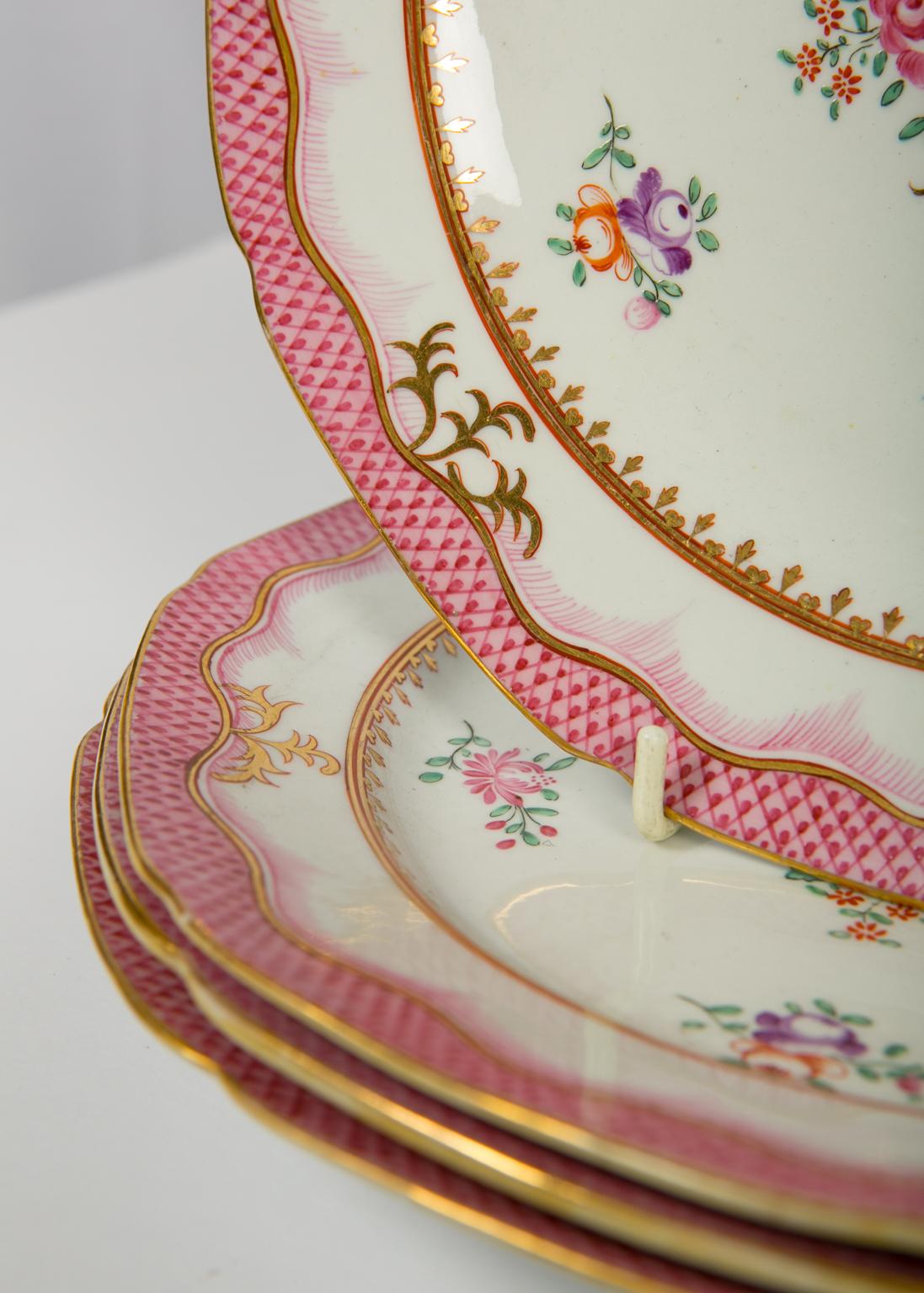 A set of four pink, antique Chamberlains Worcester dishes painted in the Famille Rose style 
circa 1830. The center of each dish shows a bouquet of flowers including a peony, a chrysanthemum, and other flowers painted in soft pink with purple,