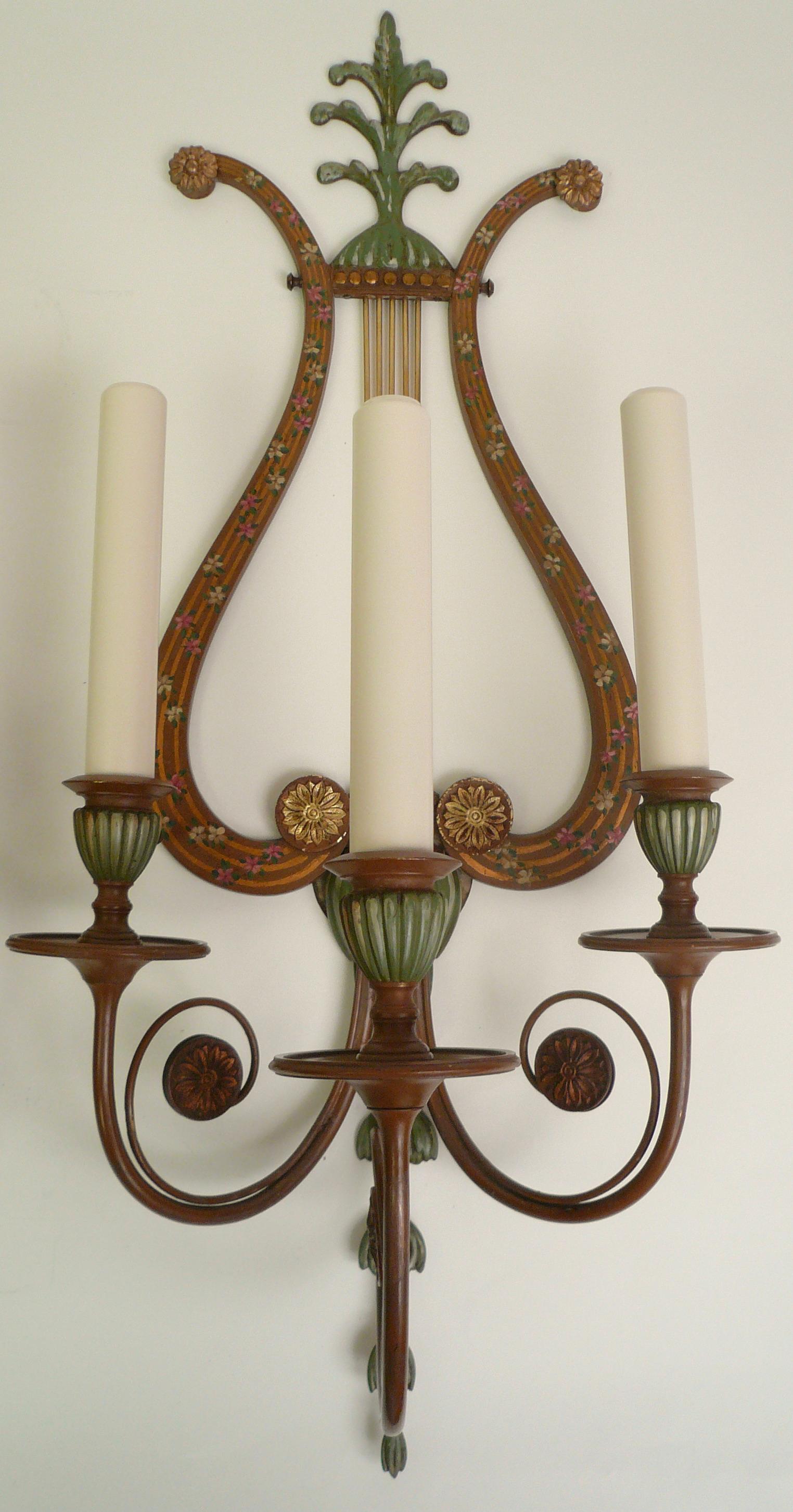This large scale set of four Neo-Classical bronze sconces are signed by the Sterling Bronze Company New York, and retain their original hand painting.The lyre form backs are painted with garlands of pink and white roses. Other motifs include