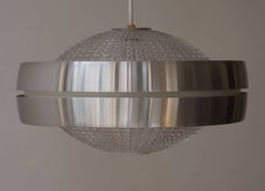 Cuatro lámparas colgantes Raak con forma de ovni de cristal y aluminio