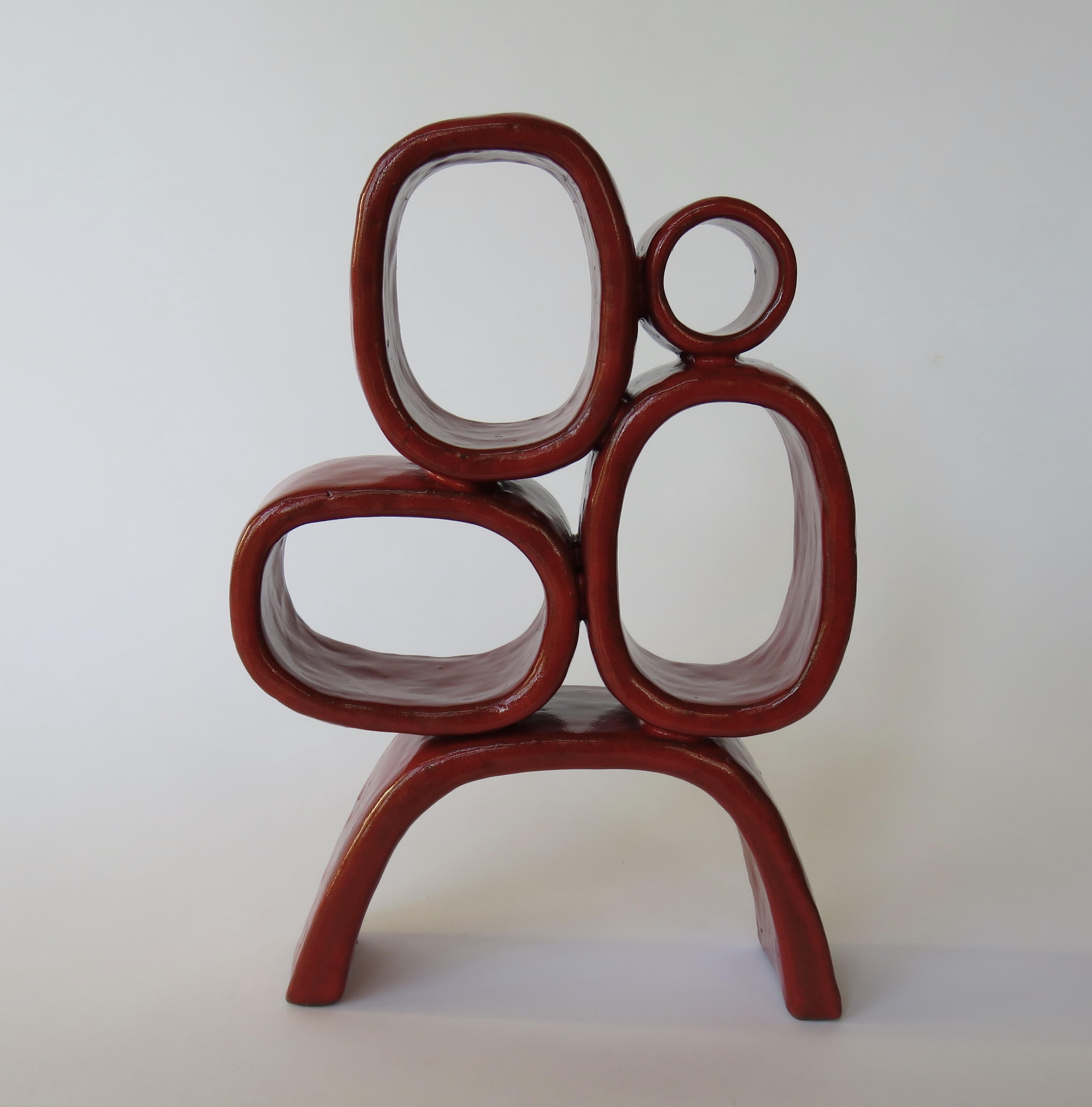 Four different-sized shiny red rectangular rings are balanced on angled legs, creating a unique Modern TOTEM. Created by Artist Helena Starcevic, this completely hand built ceramic sculpture is part of an ongoing series exploring the basic forms