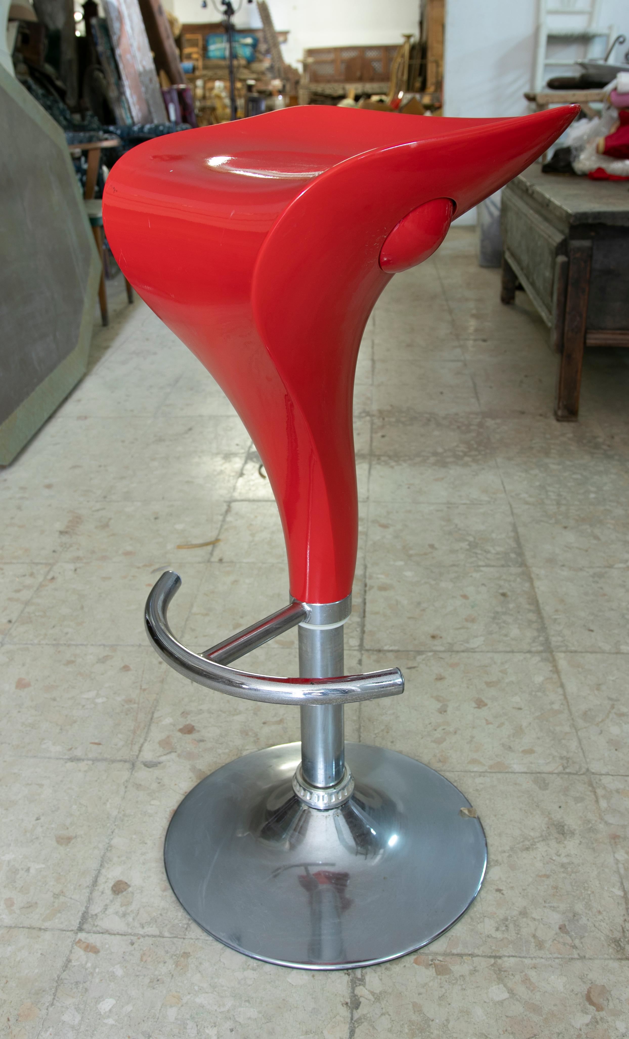 Four red stools set without backrest made in resine and steel.