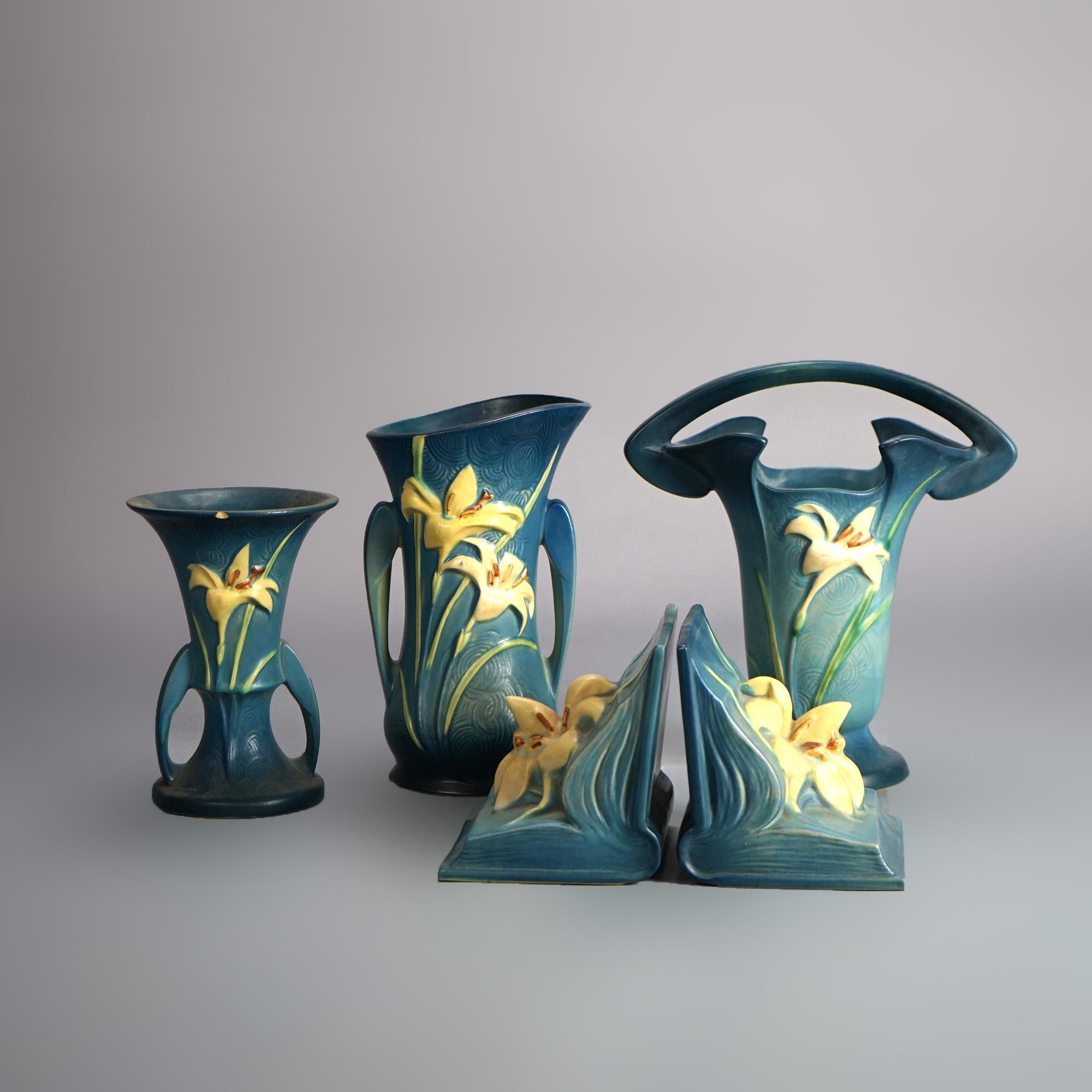 Four Roseville art pottery pieces of the Zephyr Lily Line in blue including handled vases and bookends, signed, c1946
 
Measures - 10.25
