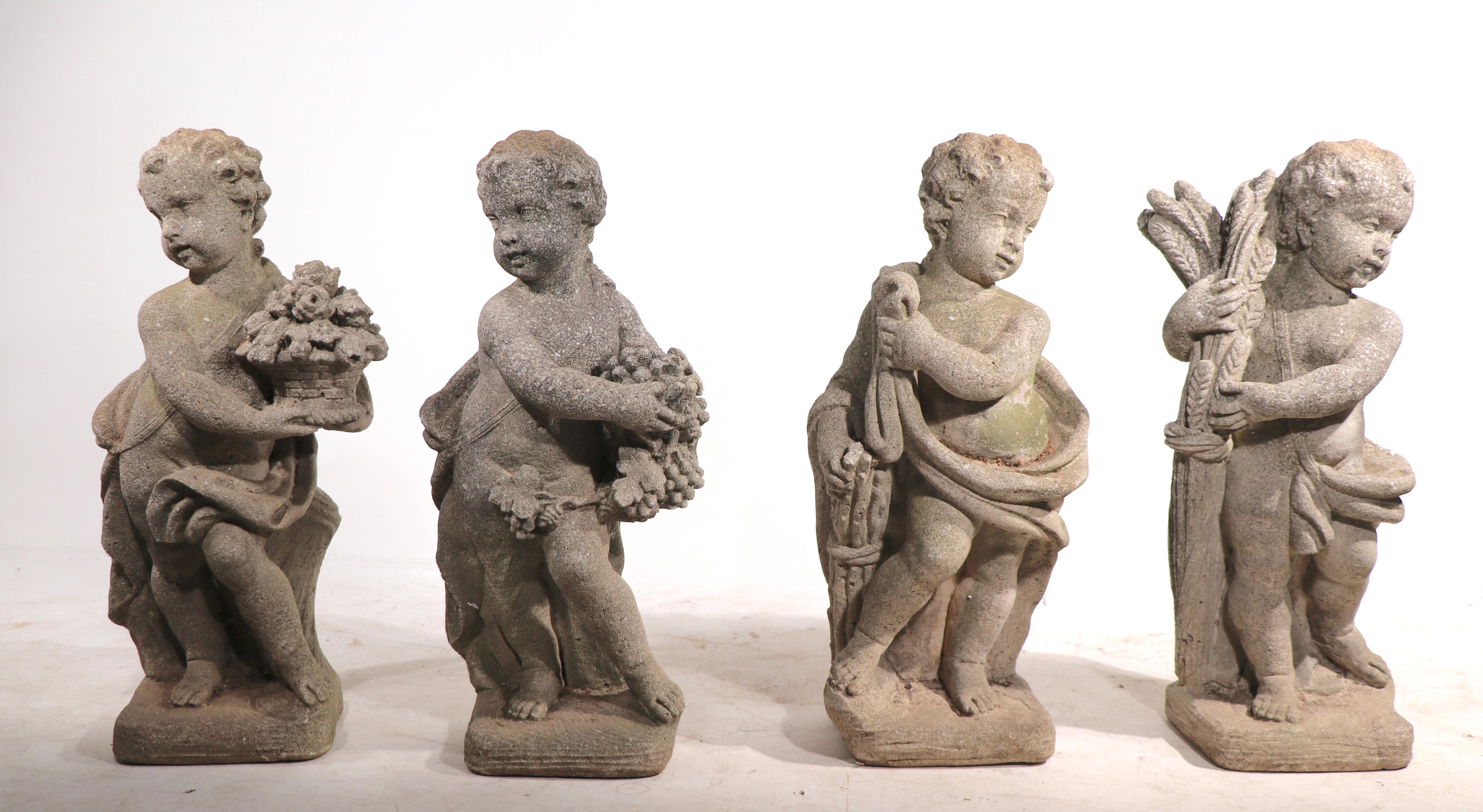 Nice complete set of vintage cast stone garden statues depicting mythological putti form representations of the four seasons. All four are in very good original condition, all have a charming organic patina. Priced and offered as a set of 4.