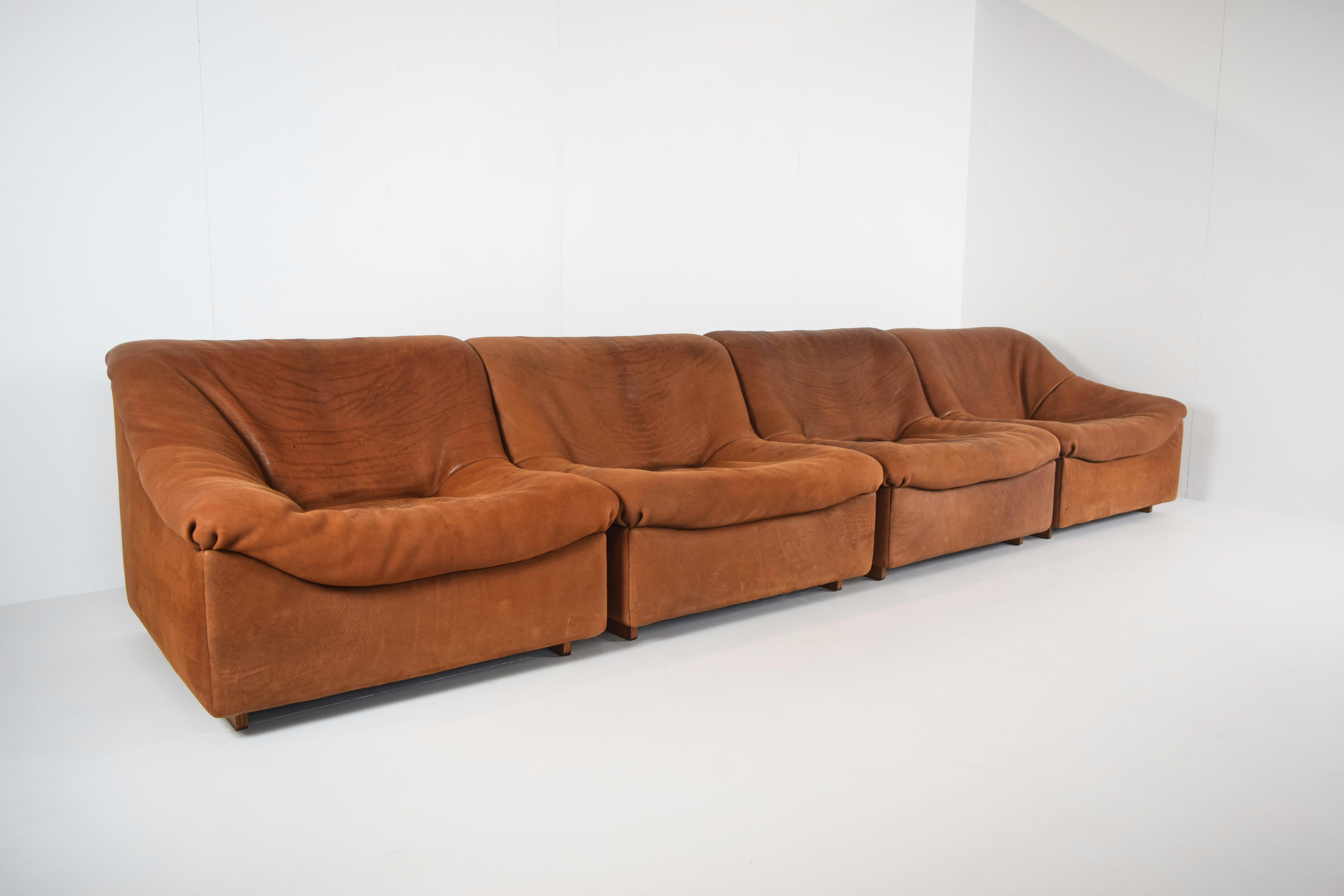 Impressive four-seat De Sede DS46 in cognac color neck leather. The four elements can be situated as one large sofa or in a 3-1 or 2-2 set-up. It clearly has a left and a right element. In total the sofa can be close to 4 meters width. This sofa