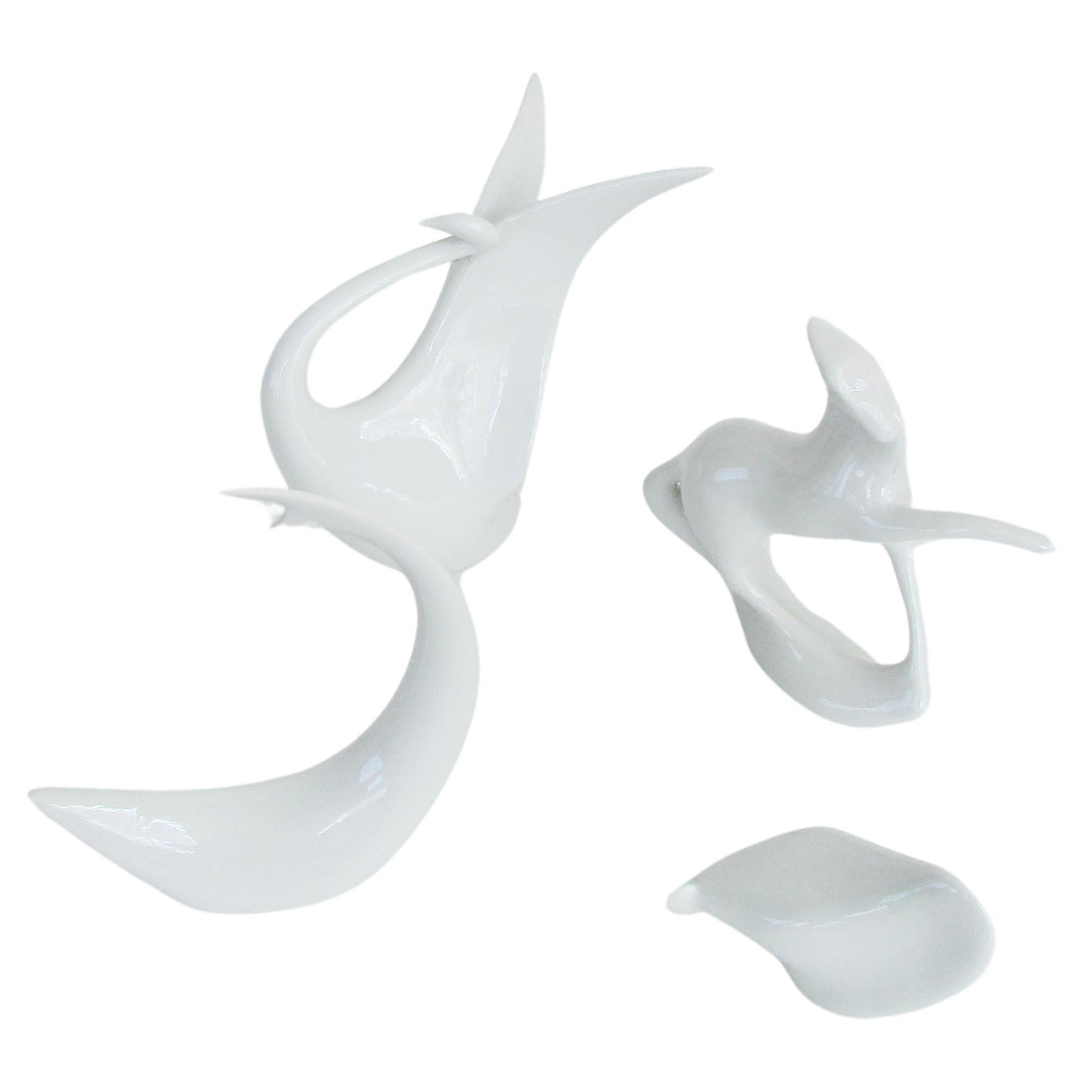 Quatre figurines distinctes de Jaroslav Jezek représentant le Royal Dux stylisé en blanc, le cygne et le cheval, le requin