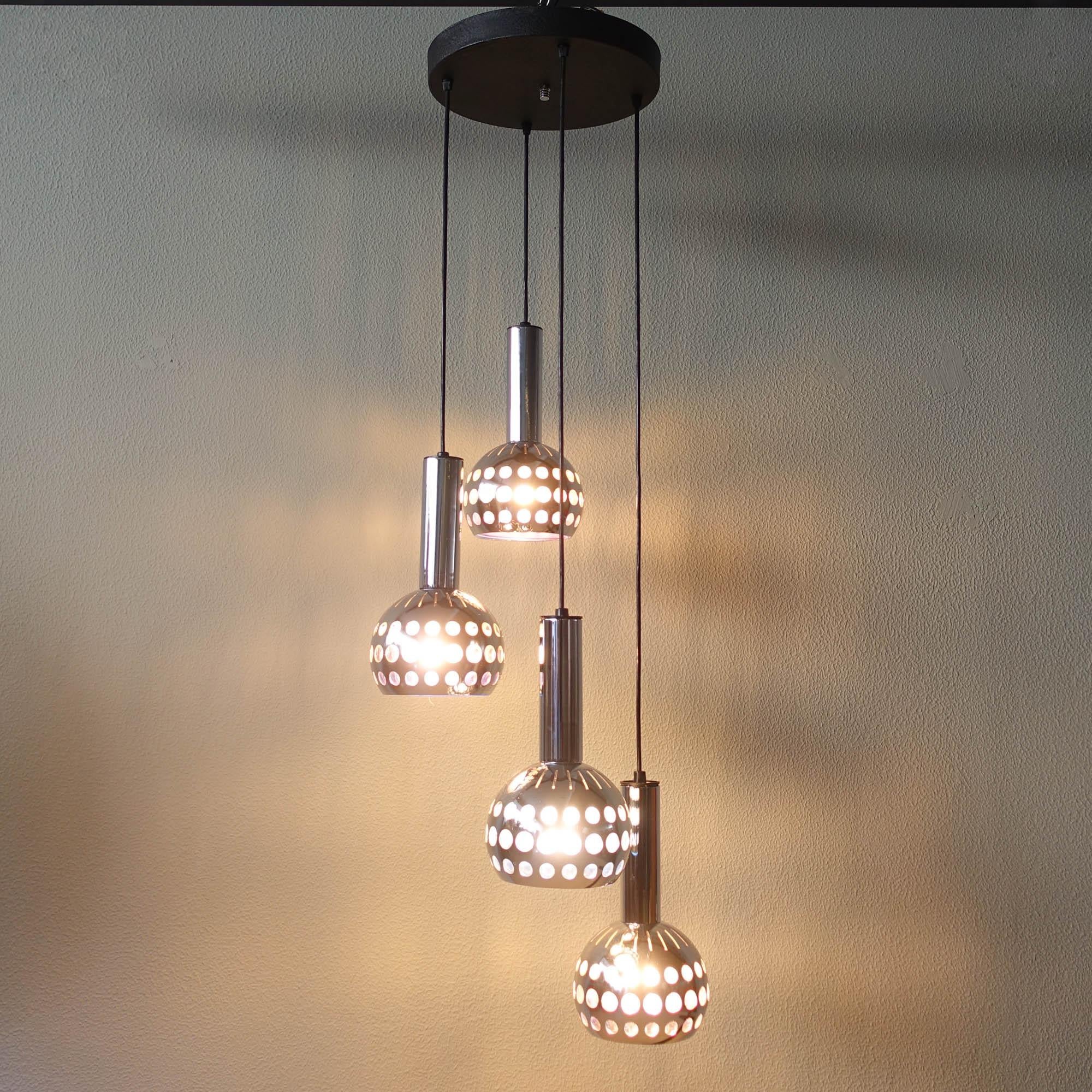 Cette lampe en cascade à quatre abat-jour en métal chromé, modèle 