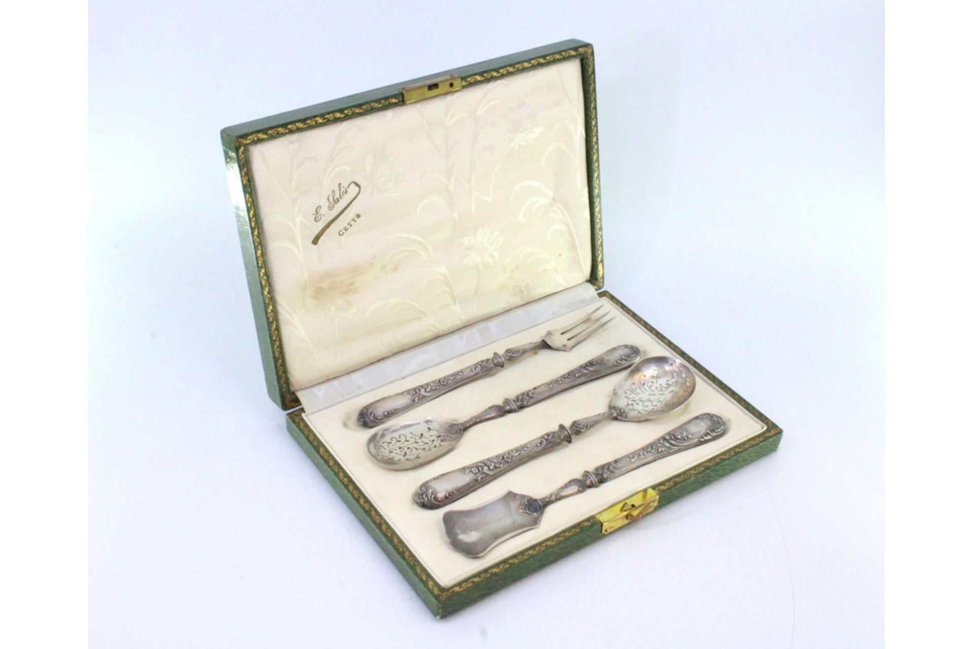 Description: Set of four silver dessert pieces with cut-out shells and raised handles with floral motifs, original case. Metal: Silver. Origin: French. Brand: Tête Minerve. Weight: 104.2 grams (Set of four pieces). Dimensions: Fork - 16.5x2.1cm