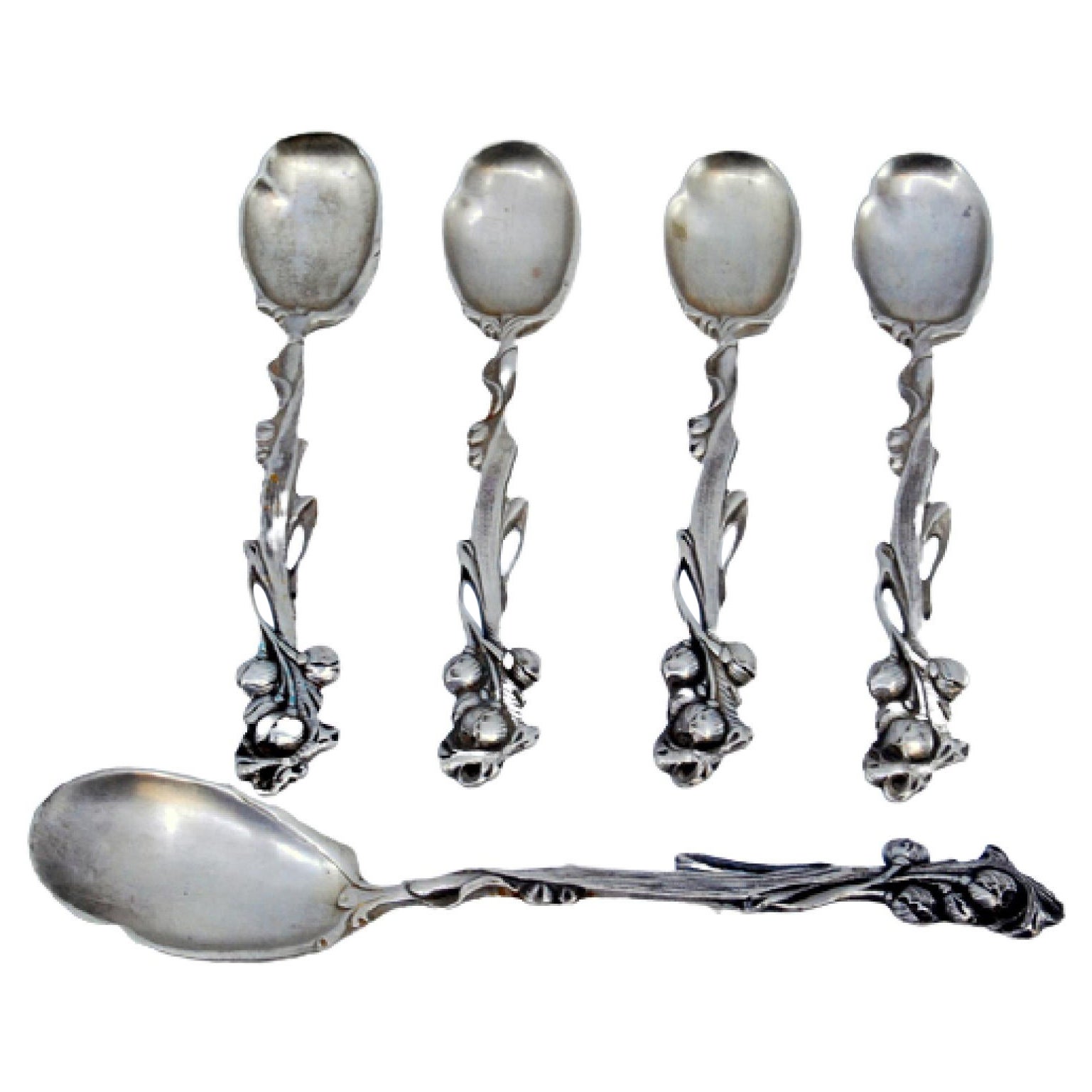 Four silver teaspoons and sugar scoop with reliefs and floral handles