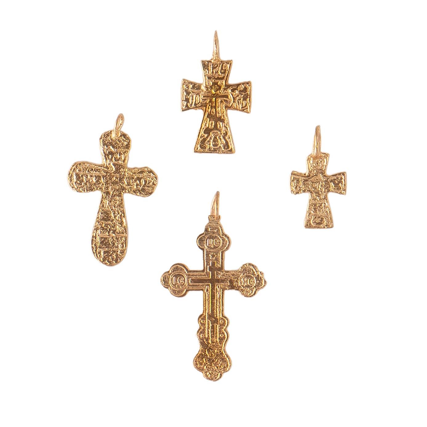A group of rare gilded Russian Orthodox pendant crosses from the era of the Romanovs of different sizes, the two smaller ones probably meant for children, each with varying stamped religious motifs including crosses. Gilded in rose gold on