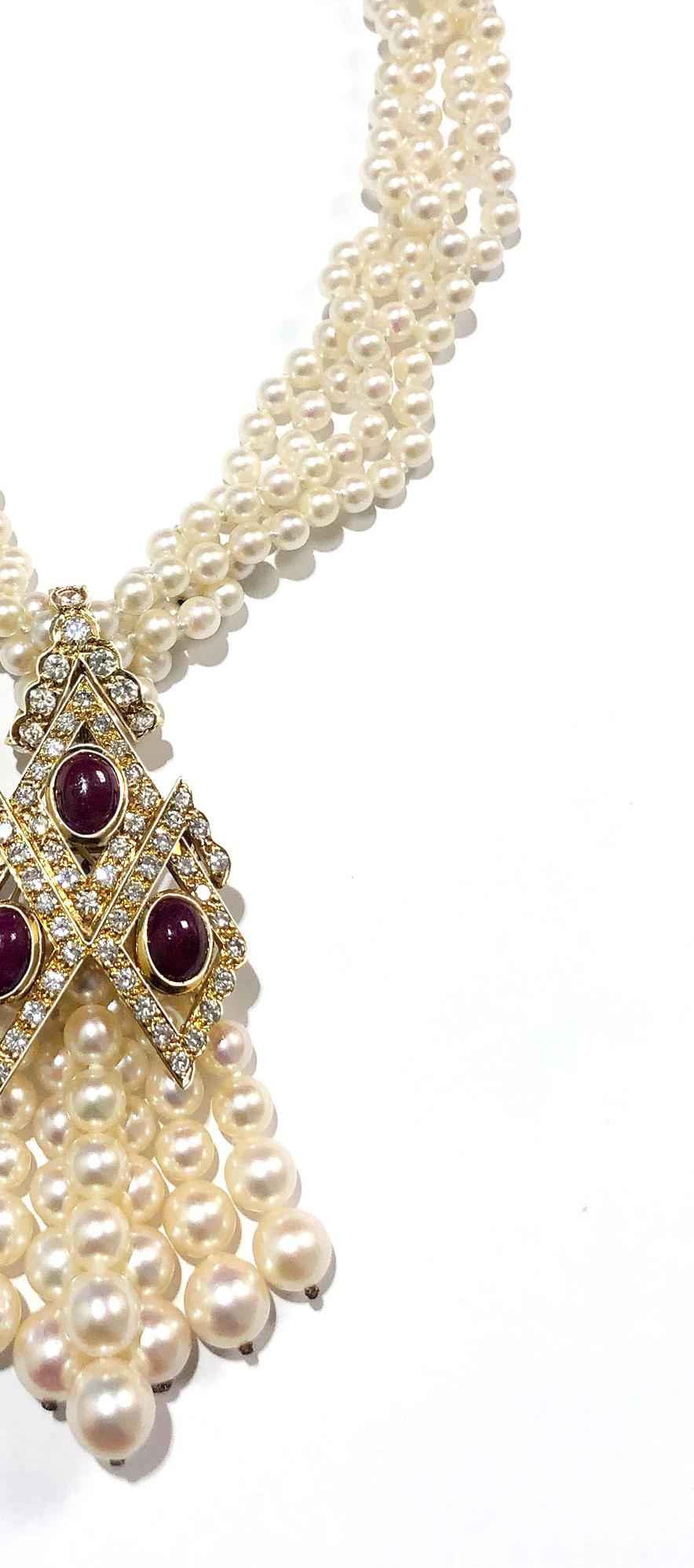 18 kt., composed of four strands of pearls approximately 4.9 to 4.5 mm., suspending and completed by 4 oval cabochon rubies, within open diamond-shaped frames of 81 round diamonds approximately 4.00 cts., the pendant suspending seven fringes of