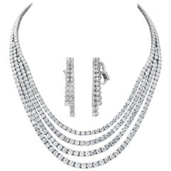 Four strand draping diamond necklace and dangling earring set in white gold.