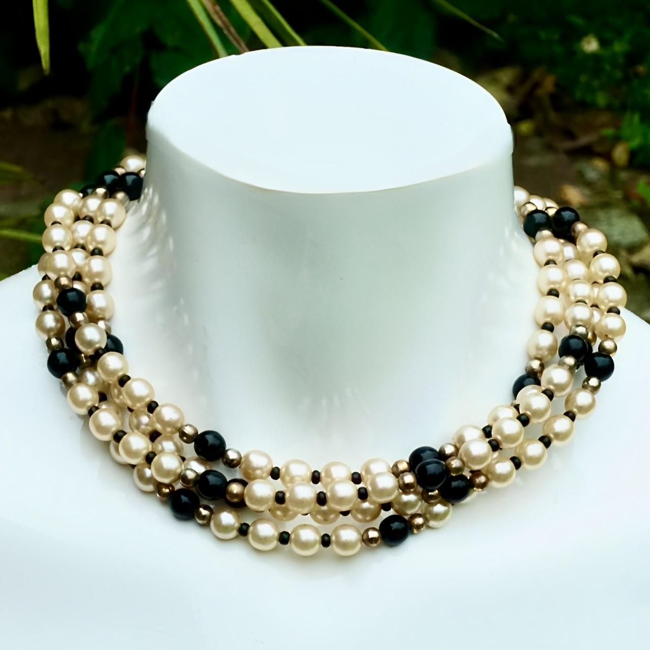 Bellissima collana di perle di vetro champagne e perle di vetro nero con sfere placcate in argento e oro. Caratterizzato da una chiusura placcata oro con smalto nero e strass. Misura circa 41,7 cm di lunghezza. La collana è in ottime condizioni. Le