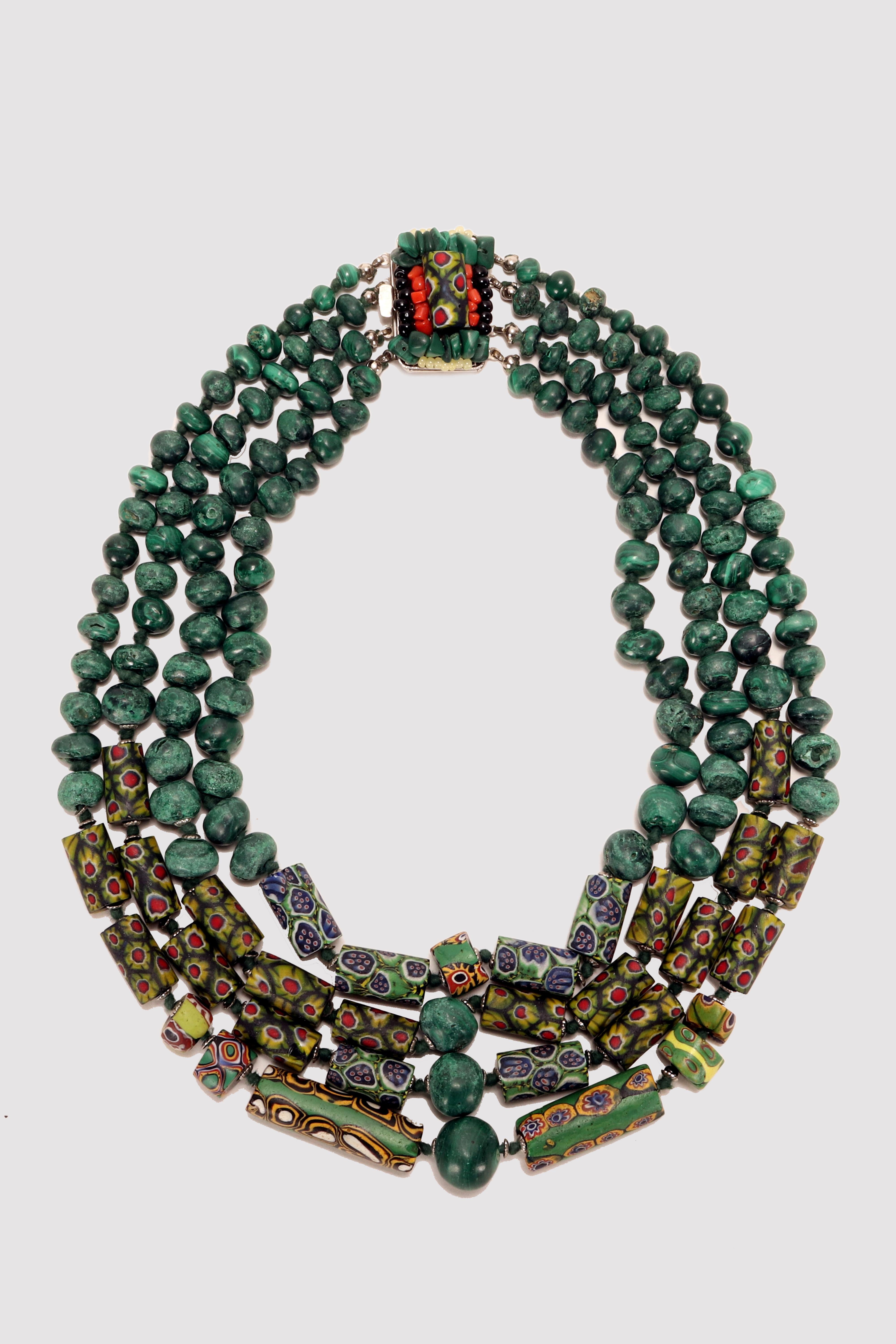 Four-strand malachite necklace with Venetian millefiori cylindrical beads. The necklace is made of malachite beads set in four strands of progressive length, enriched with a sequence of Venetian glass cylindrical beads. The white metal clasp is