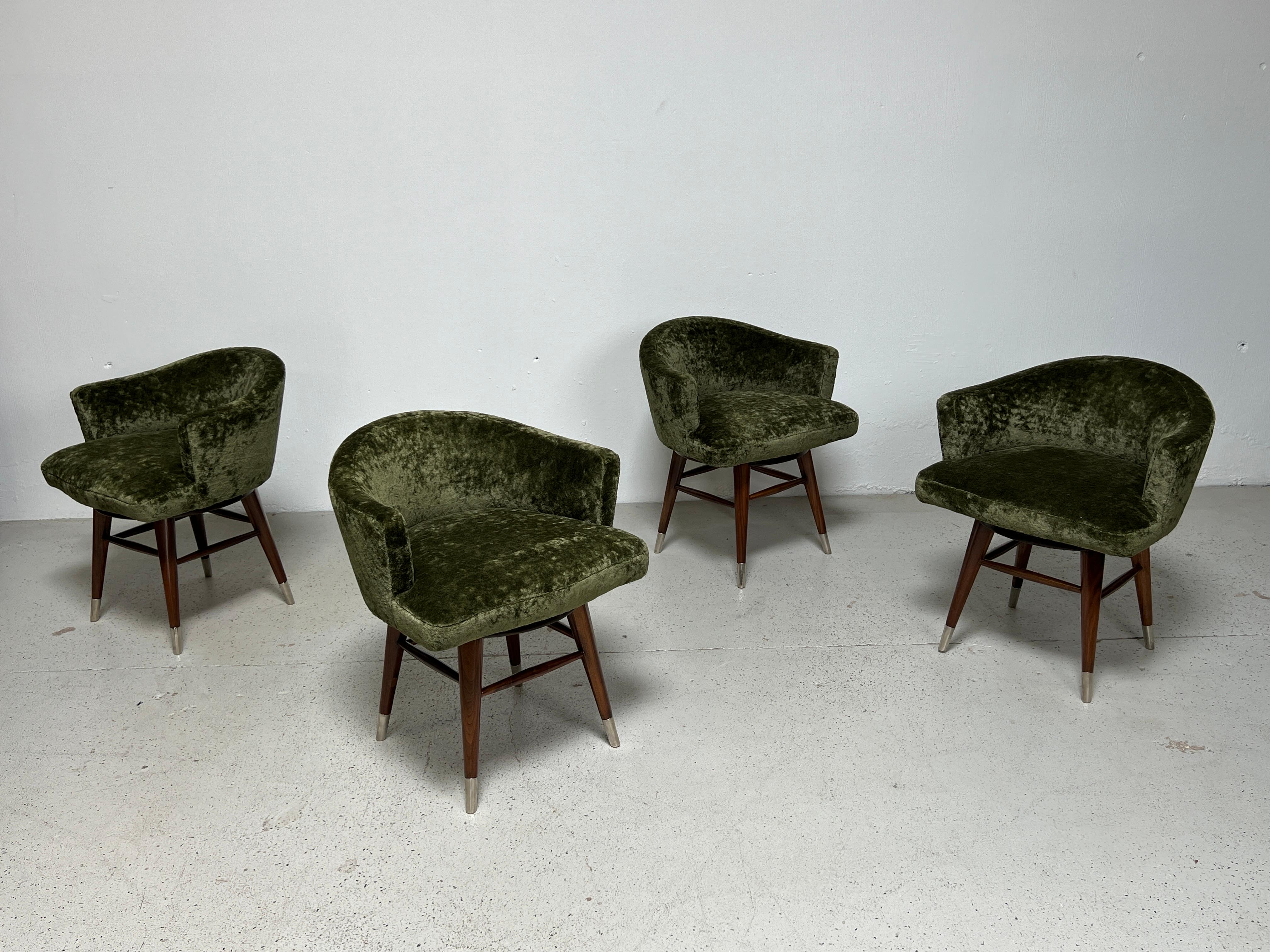 A set of four Edward Wormley for Dunbar swiveling stools / chairs with mahogany legs and chrome sabots. Fully restored and upholstered in Holly Hunt / Lush / Palm thick velvet.
