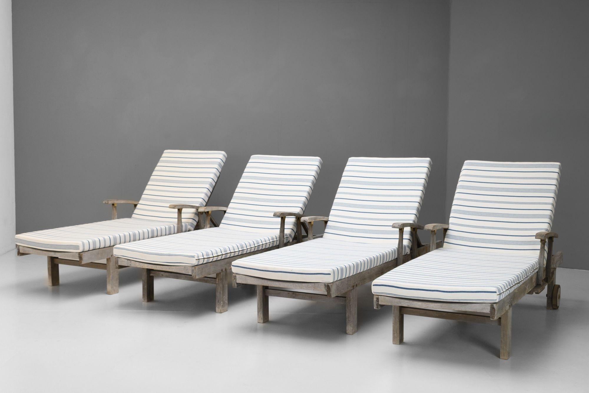 Quatre chaises longues en teck avec dossiers réglables et tables d'appoint.

K.K. vers 1960.

H 35cm x L 200cm x P 77cm