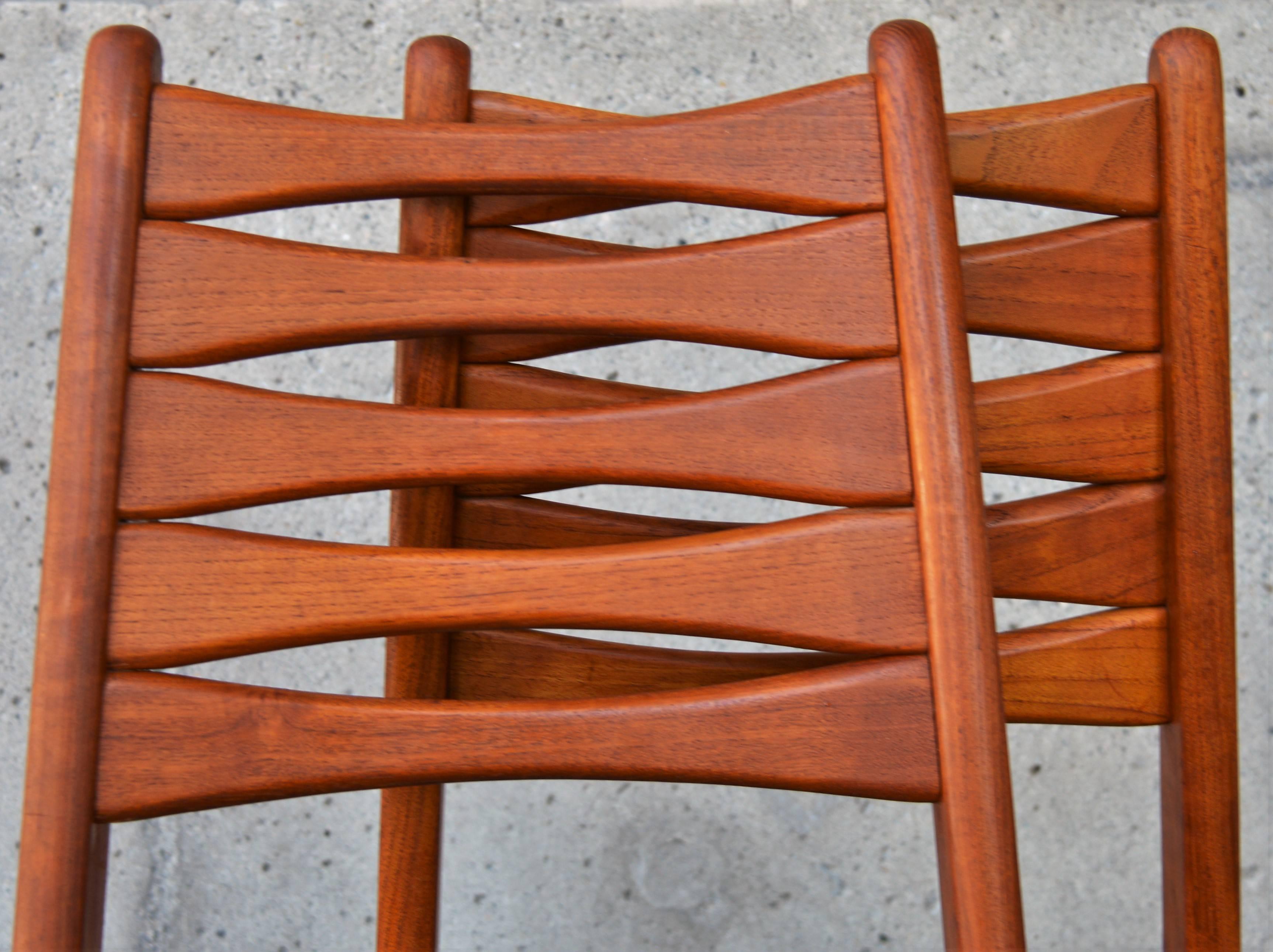 This lovely set of tall back Danish modern teak ladder back chairs have really pretty detailing throughout. Note the bow-tie shaped rungs on the back rest, as well as below the seat in the front and back. Also, the pretty sculptural design of the