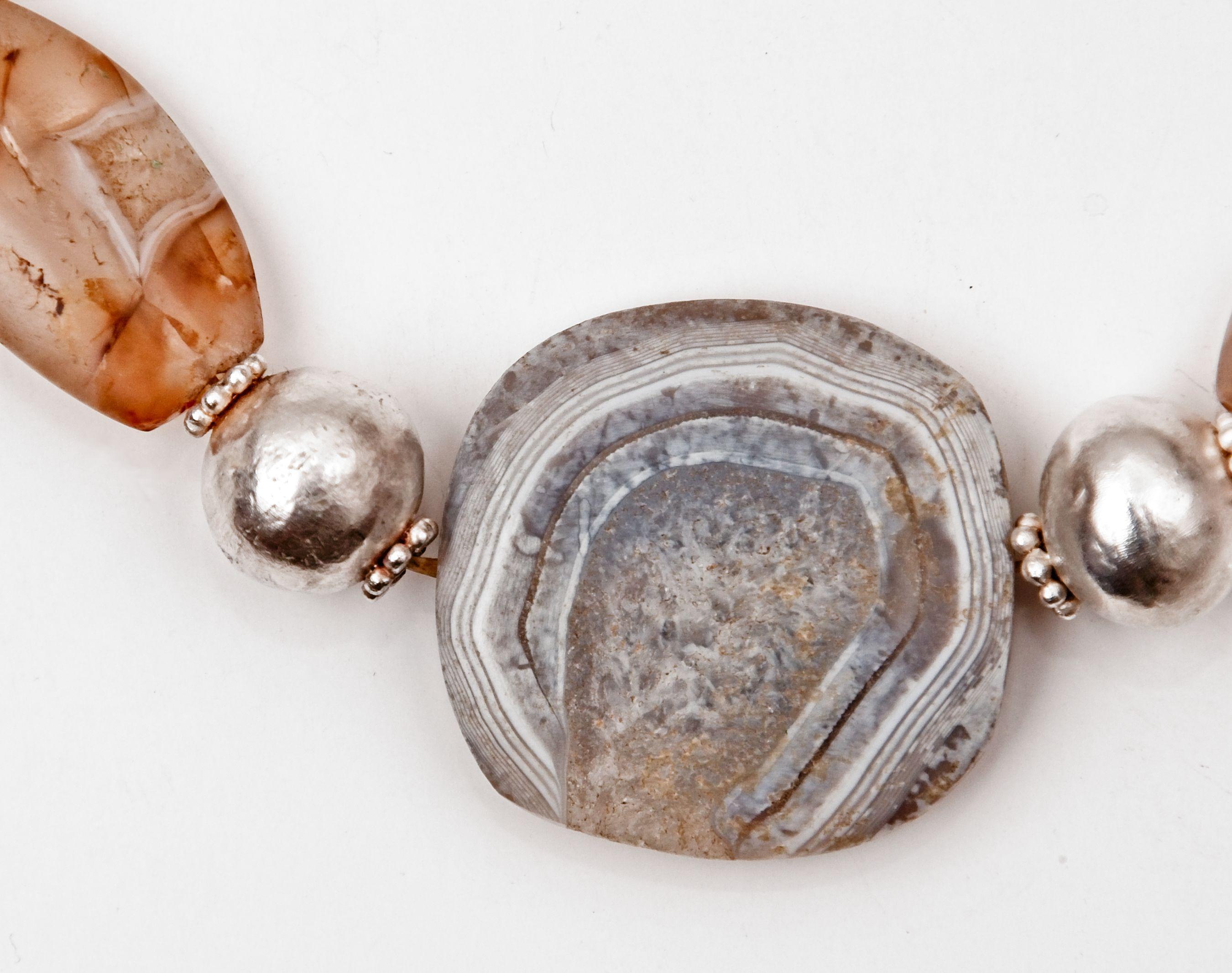 Seventeen Bronze Age agate beads alternating with sixteen Fine silver beads. Ten of the silver beads are spherical with granulated collars, six of the beads are composed entirely of grains, two tiers of six grain circlets, and two of these beads